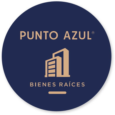 Logotipo circular con fondo azul oscuro que dice 'PUNTO AZUL', 'BIENES RAÍCES' y tiene una ilustración de un edificio en el centro.