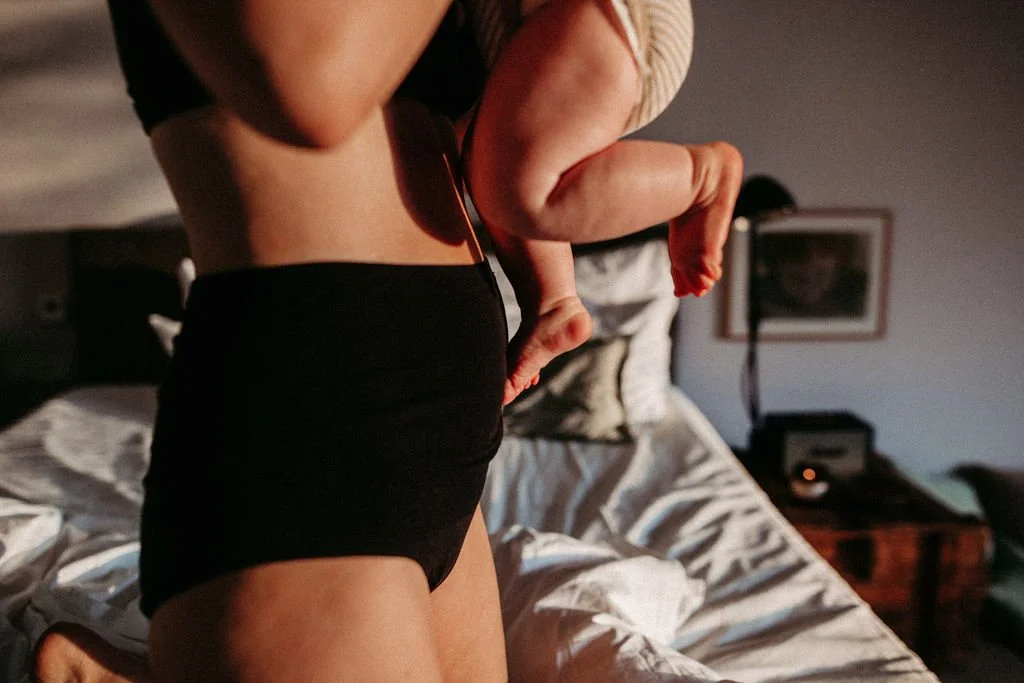 Eine Mutter hält ihr Baby im Wochenbett