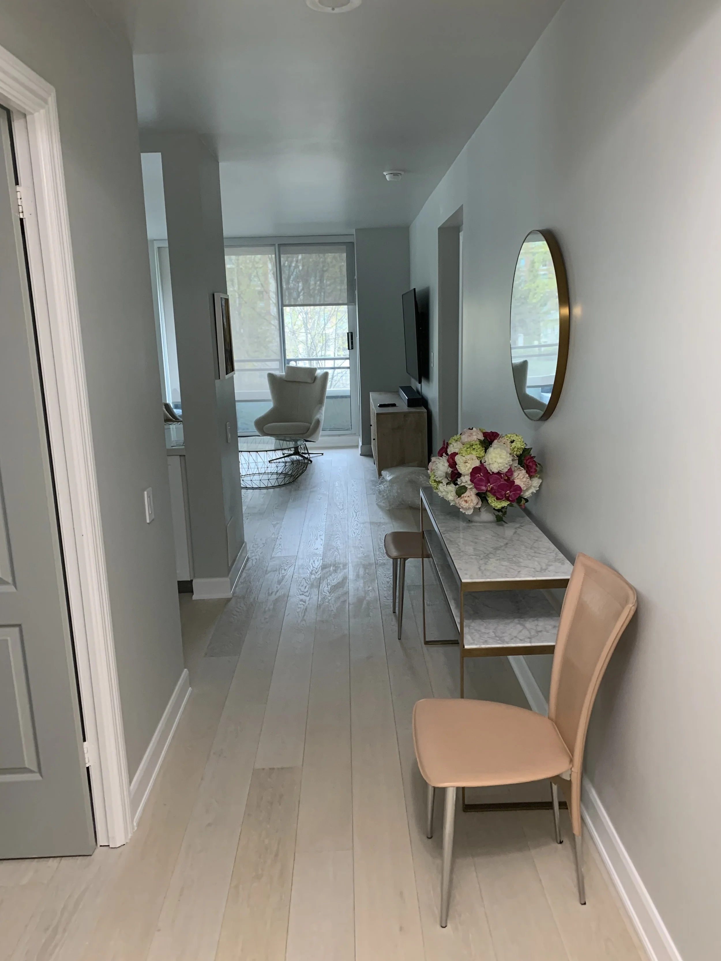 The hallway of a newly renovated modern condo with a mirror and painted walls