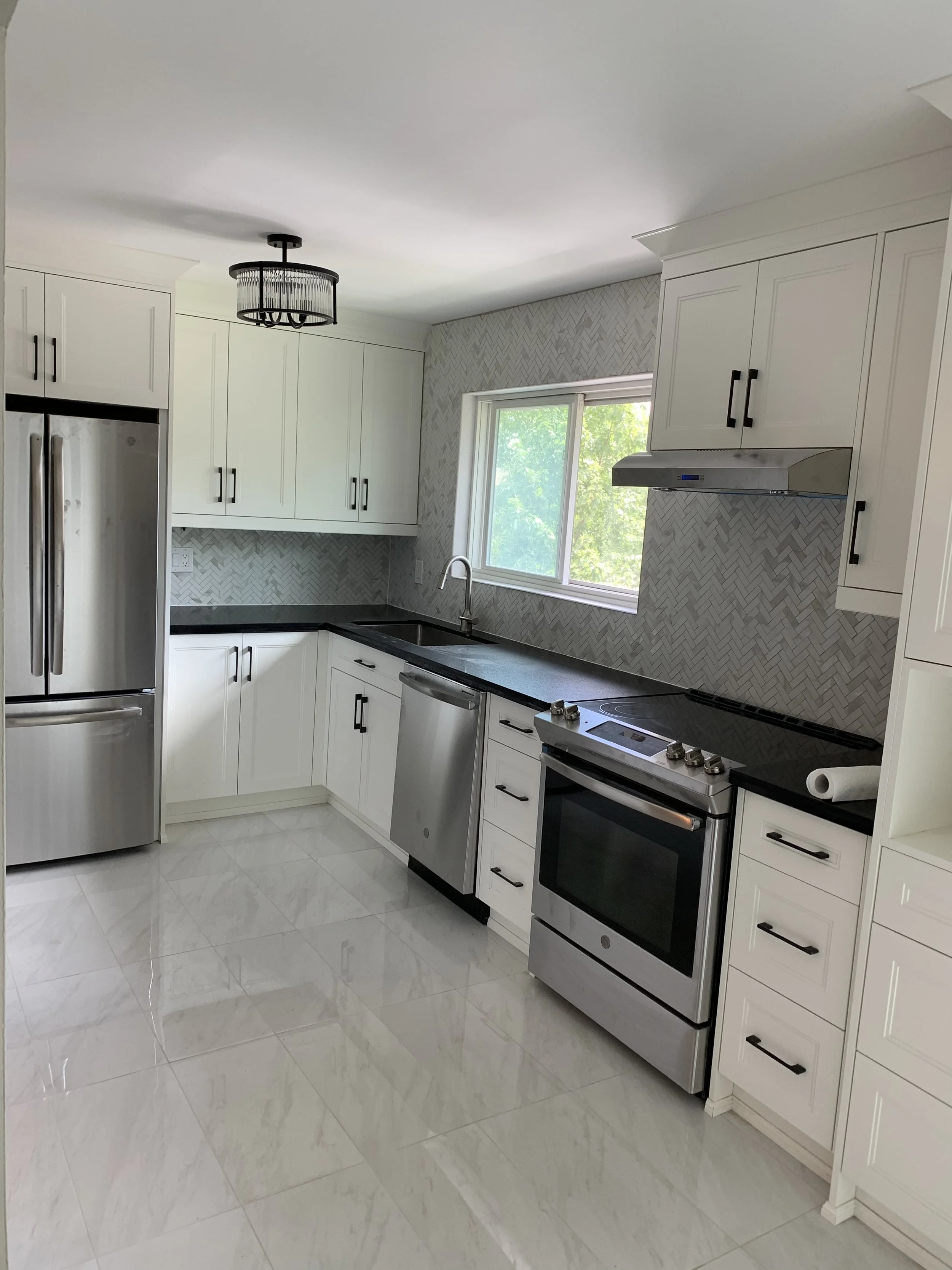 New fridge and stove with clean tiles in a renovated kitchen