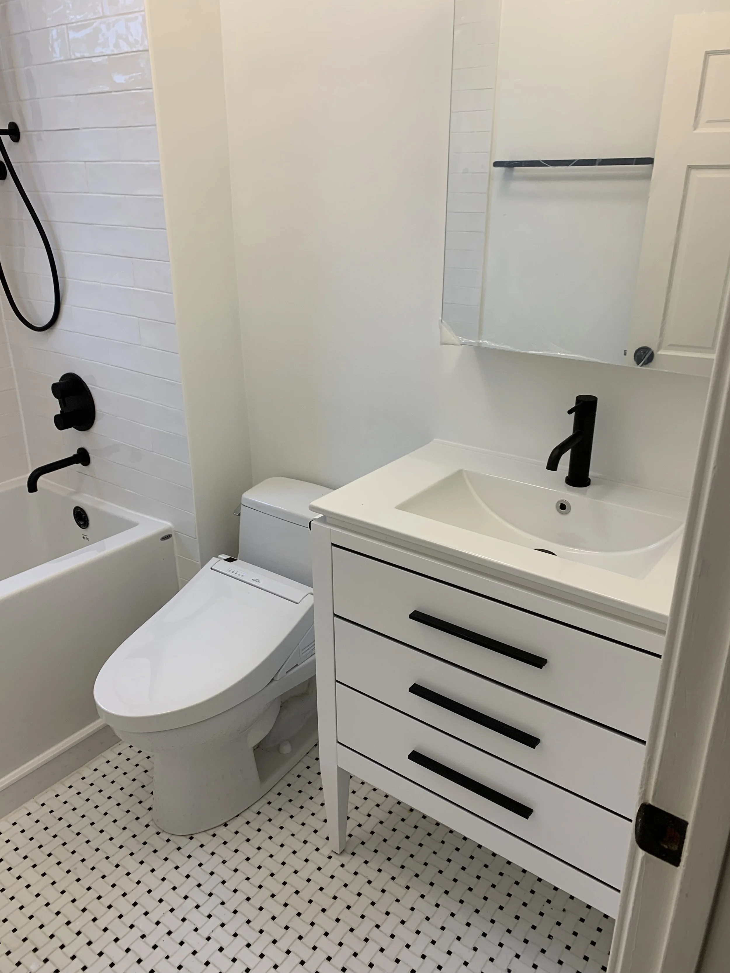 Bathroom renovated with new tiles, vanity, and toilet