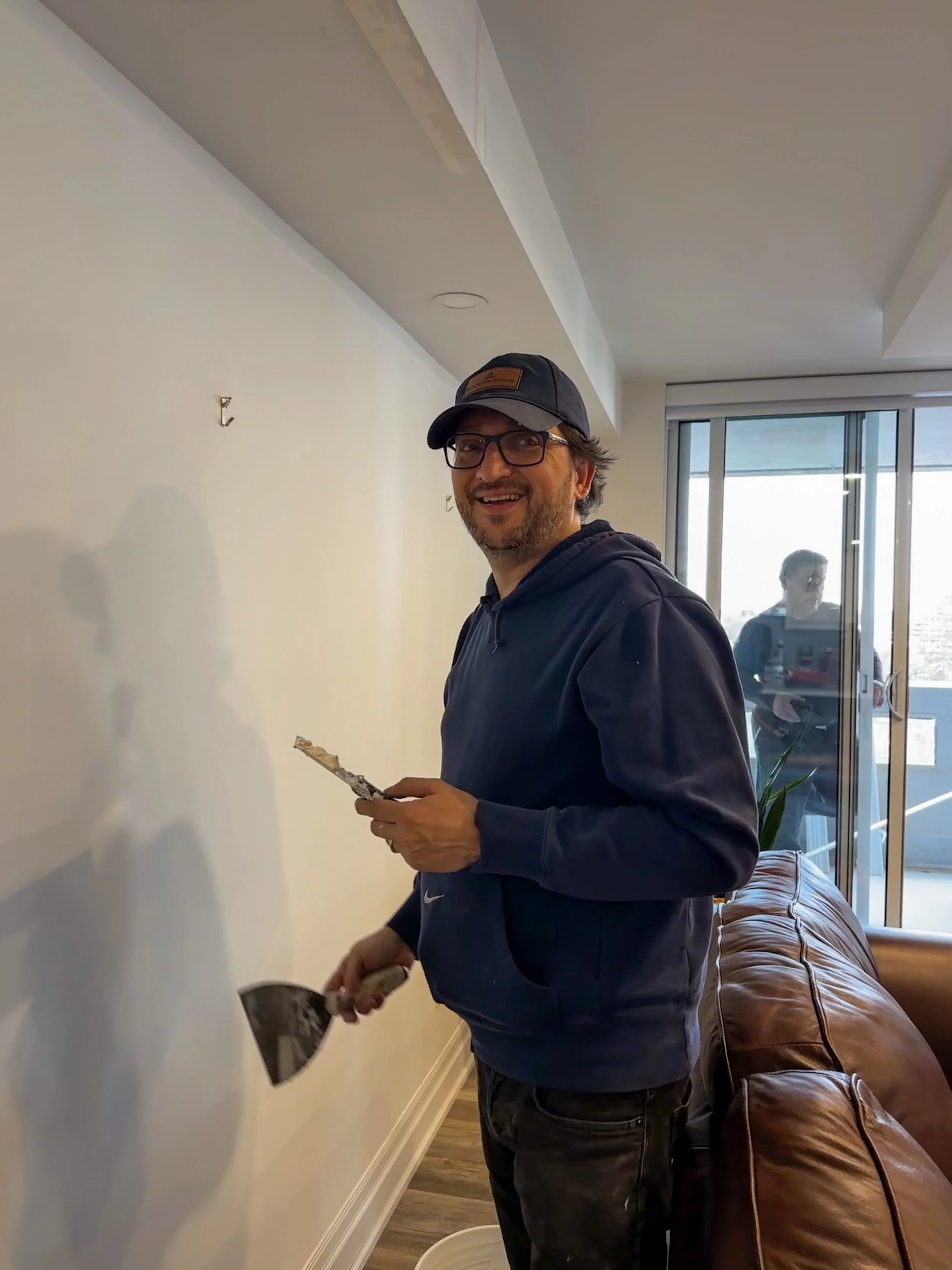 Raptor Remodelling owner Viktor placing plaster on the wall of renovation