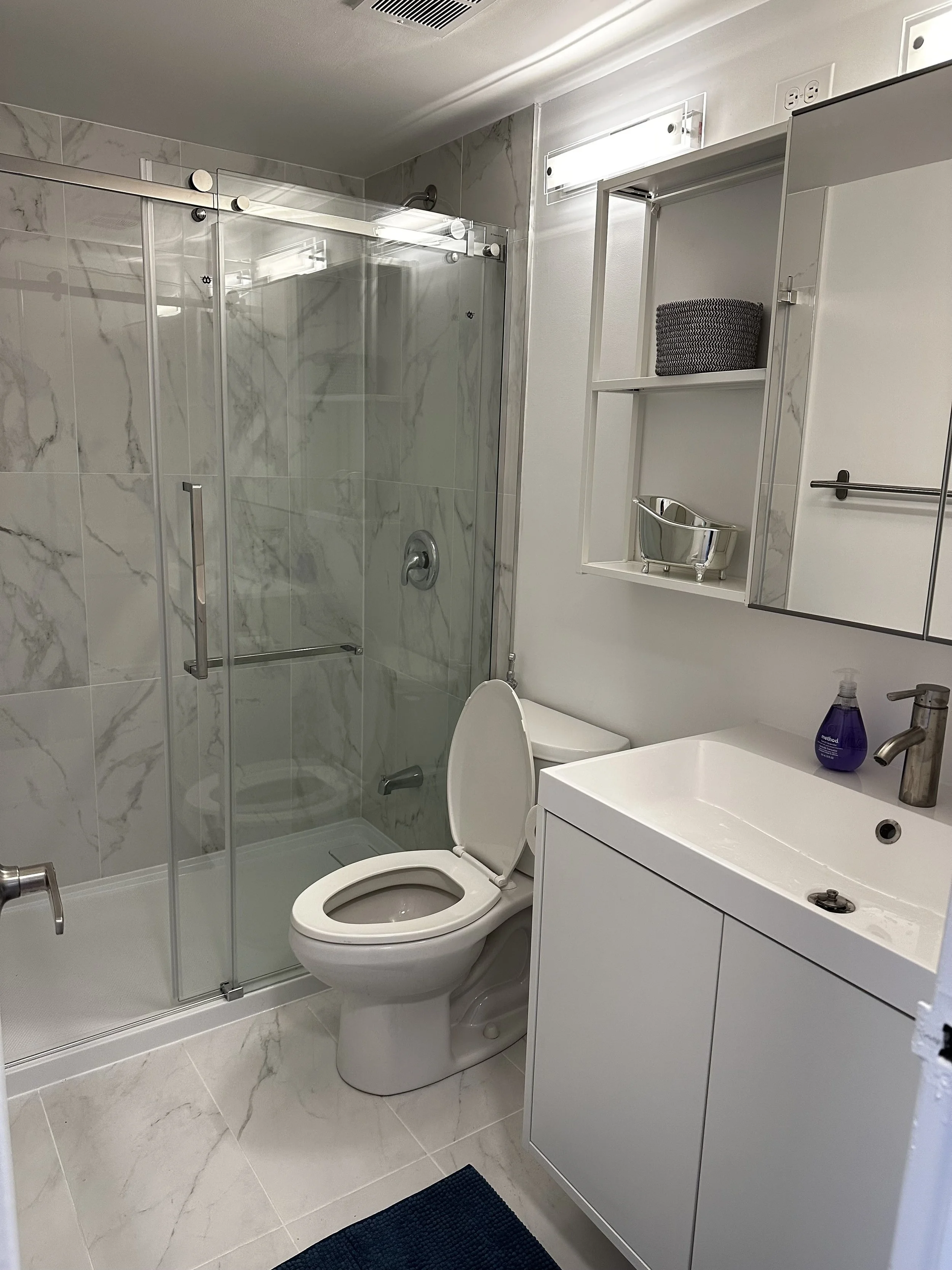 Renovated white bathroom with silver tiles