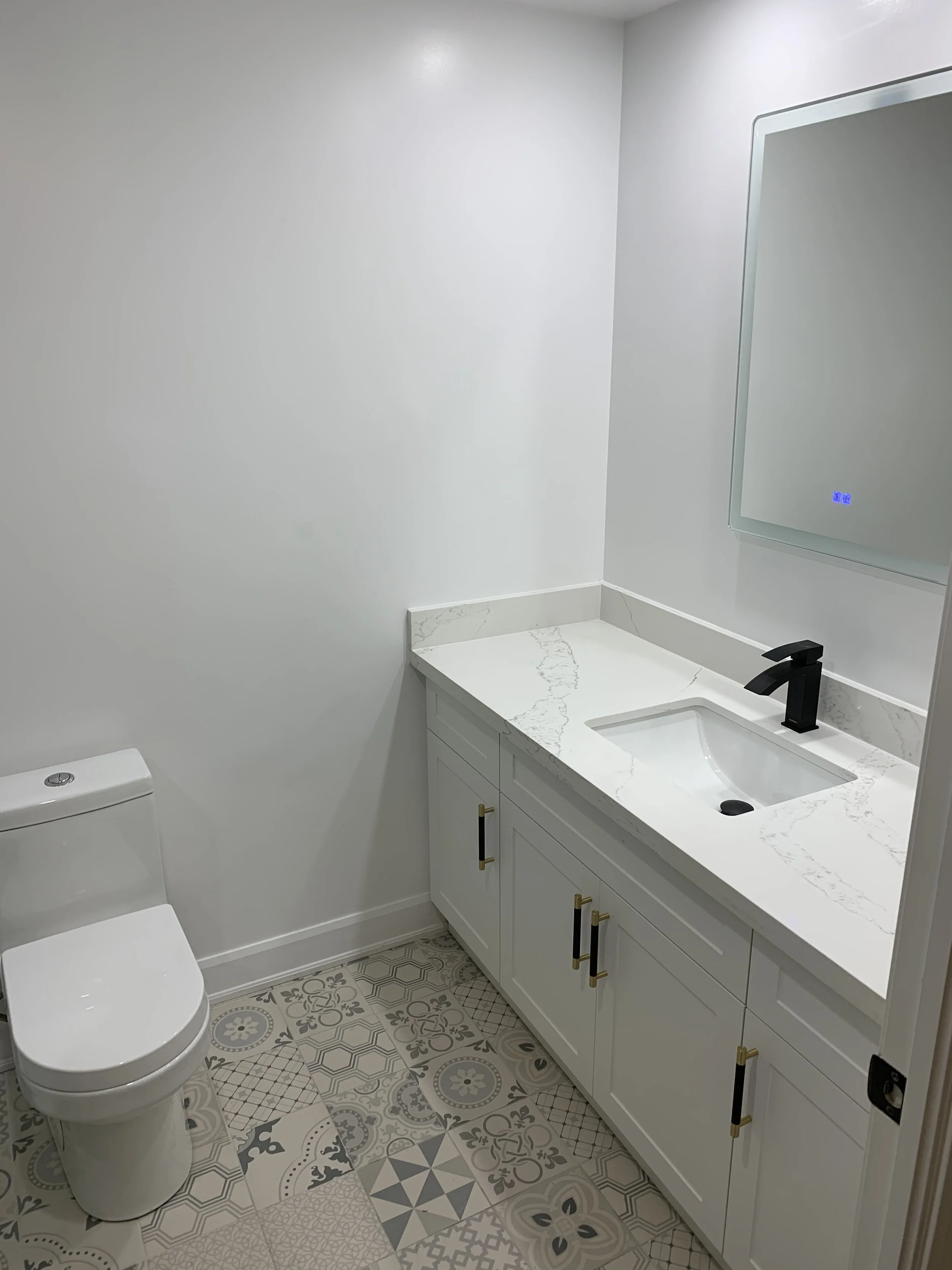 New vanity and toilet in a renovated bathroom with modern tiles