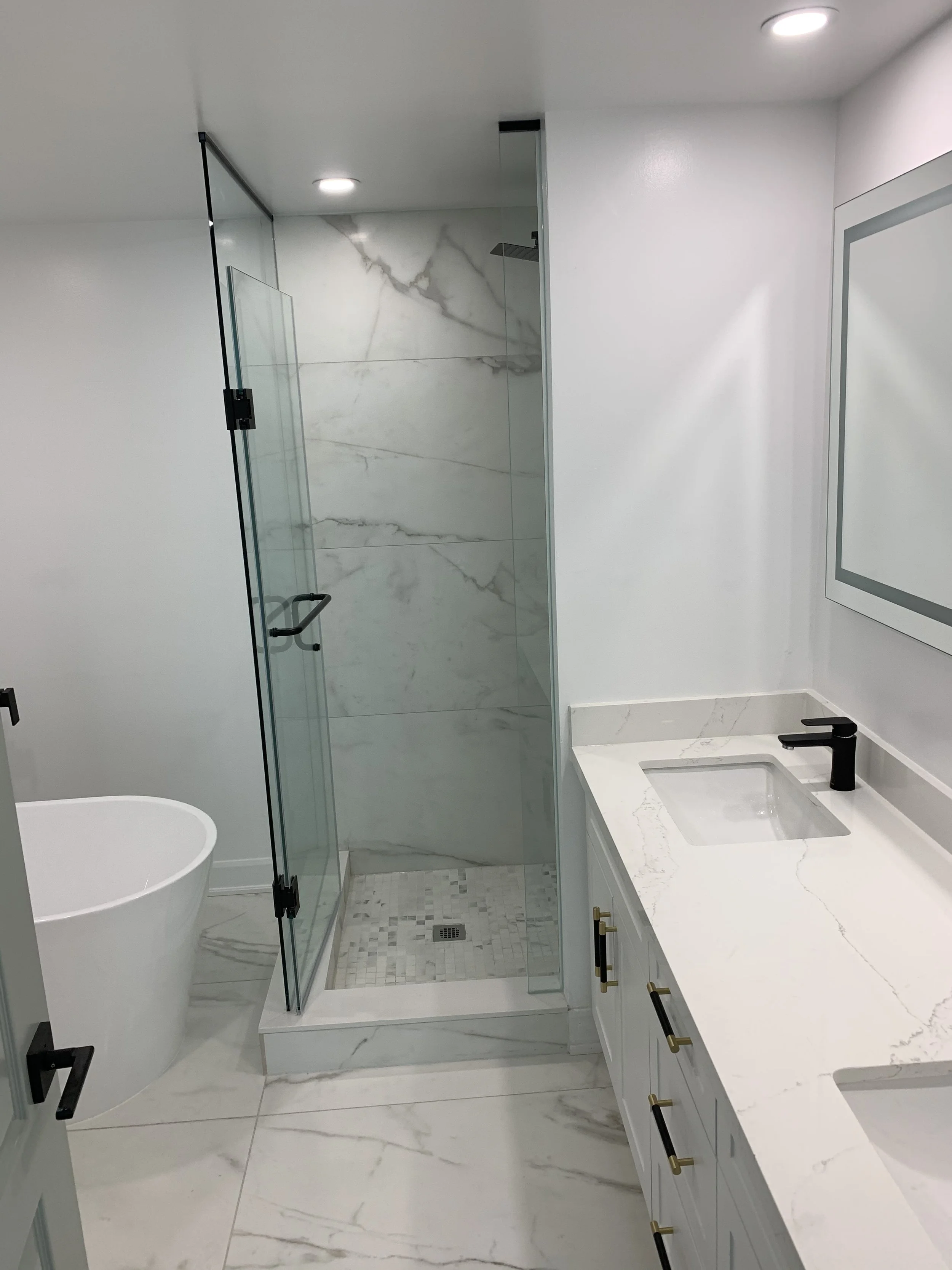 Fully renovated white bathroom, new tiles and shower, white vanity and mirror