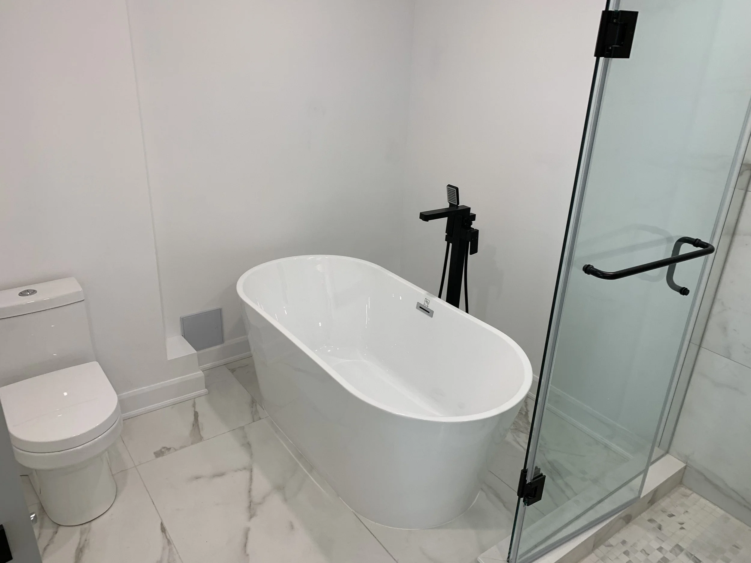Bathtub in renovated white bathroom