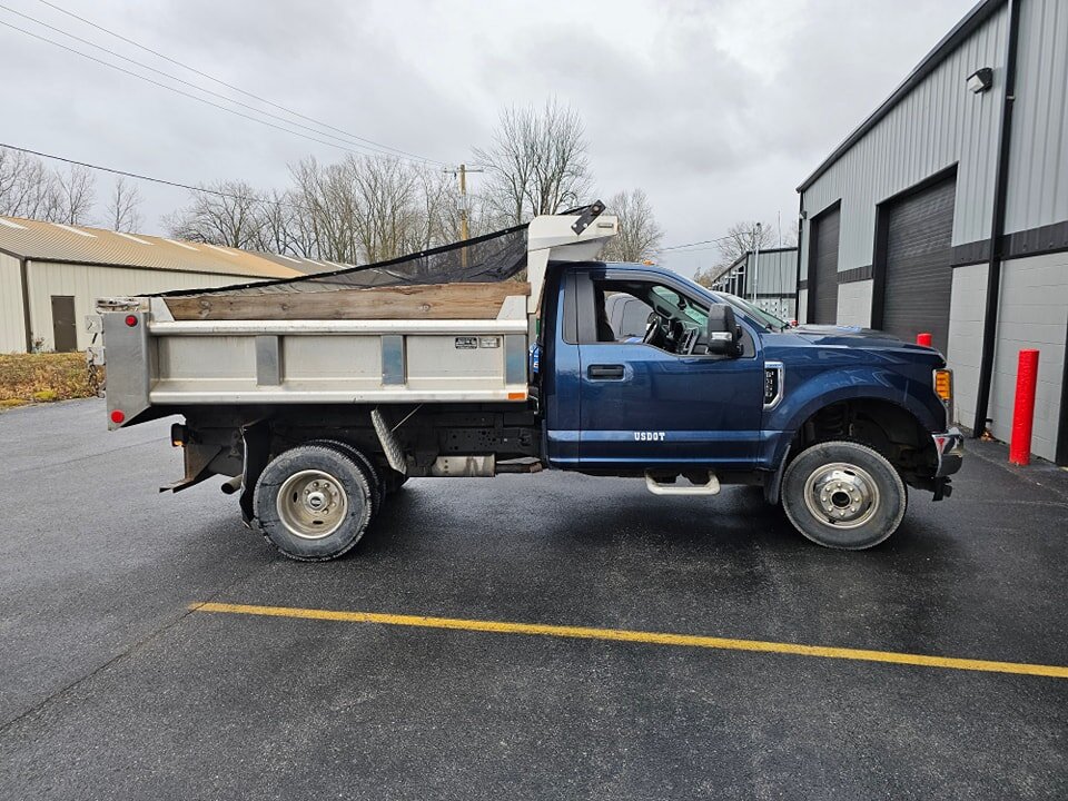 Before and after shots on this dump truck. We wrapped the cab white to match their existing fleet and added spot graphics.