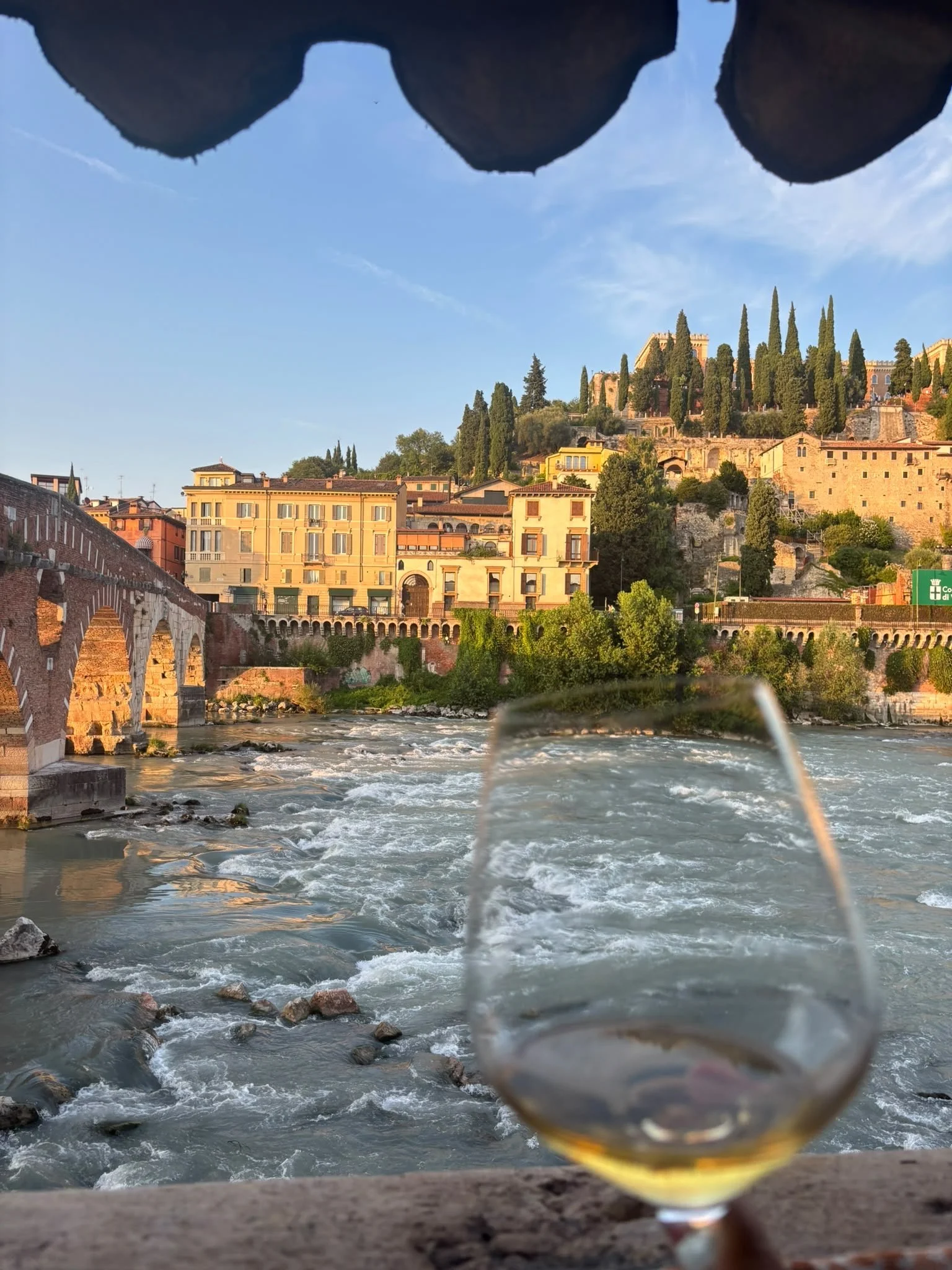 Wine glass overlooking the Adige river and Ponte Pietra bridge from Michelin Osteria Ponte Pietra in Verona