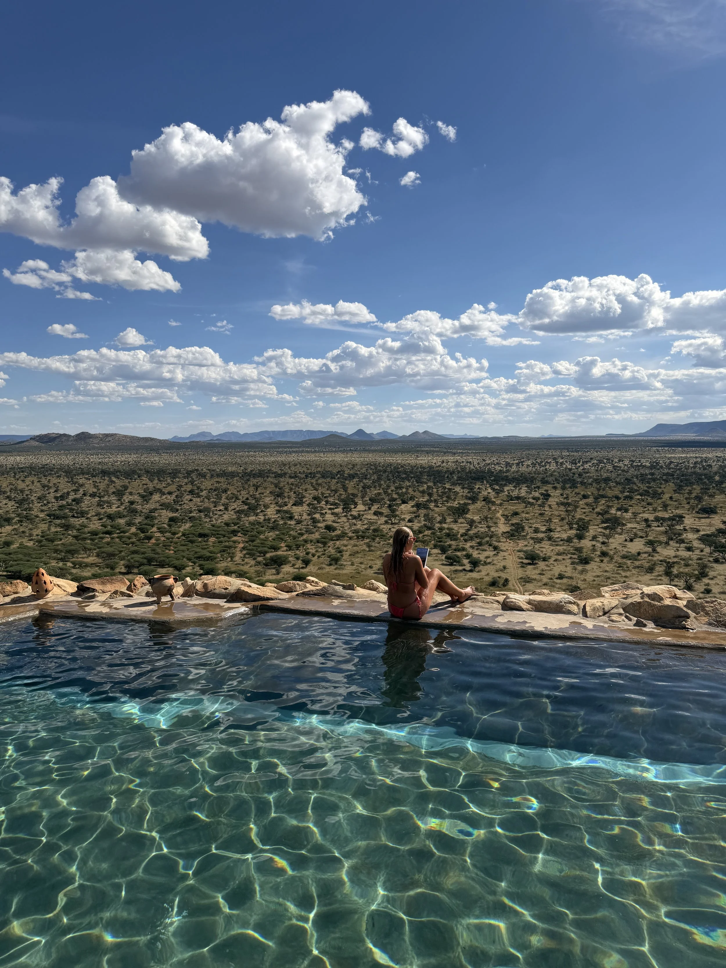 Infinity pool at Habitas Namibia overlooking the desert safari landscape