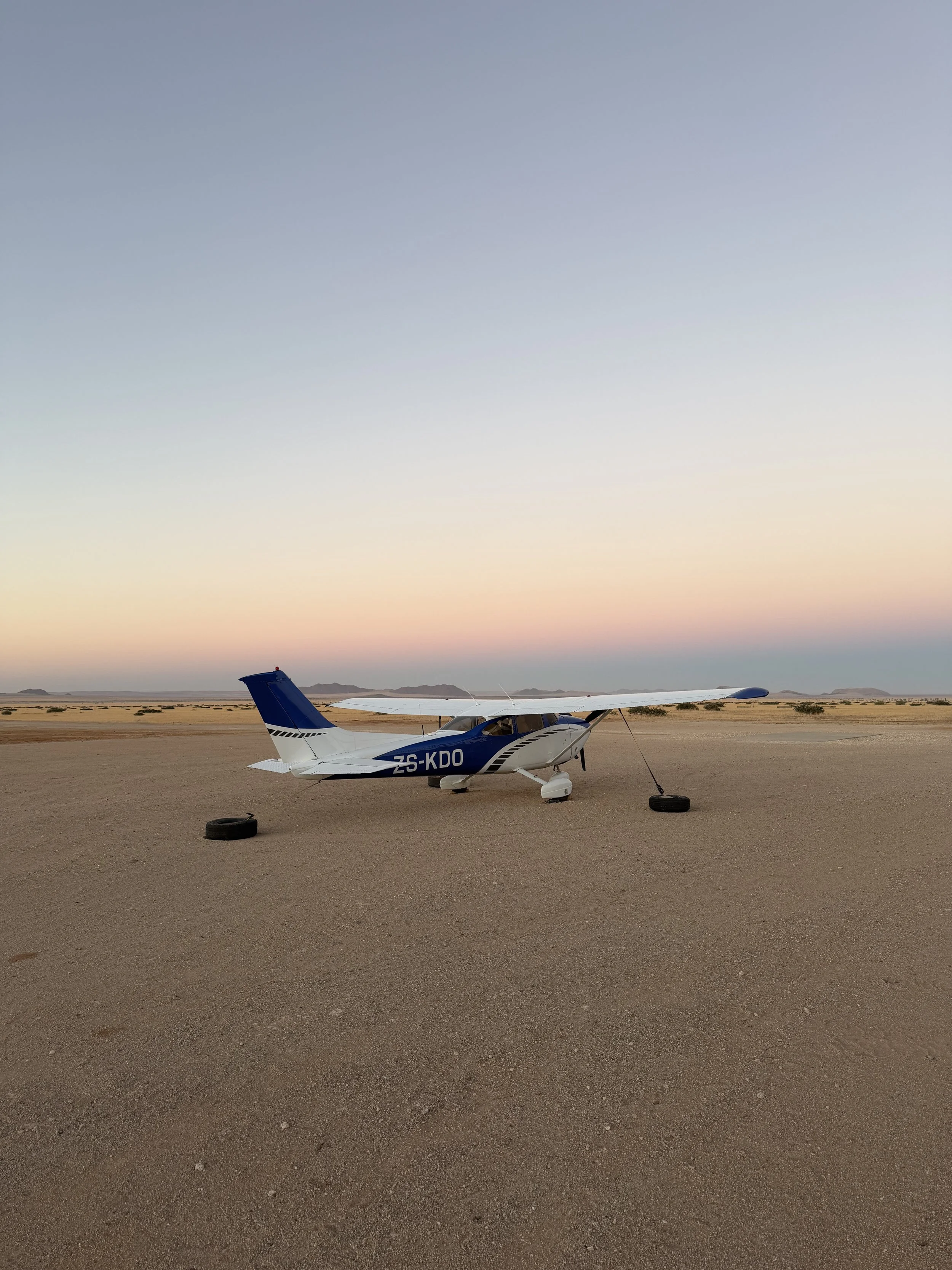 Private plane parked on a desert airstrip near Solitaire, Namibia, at sunset and sunrise