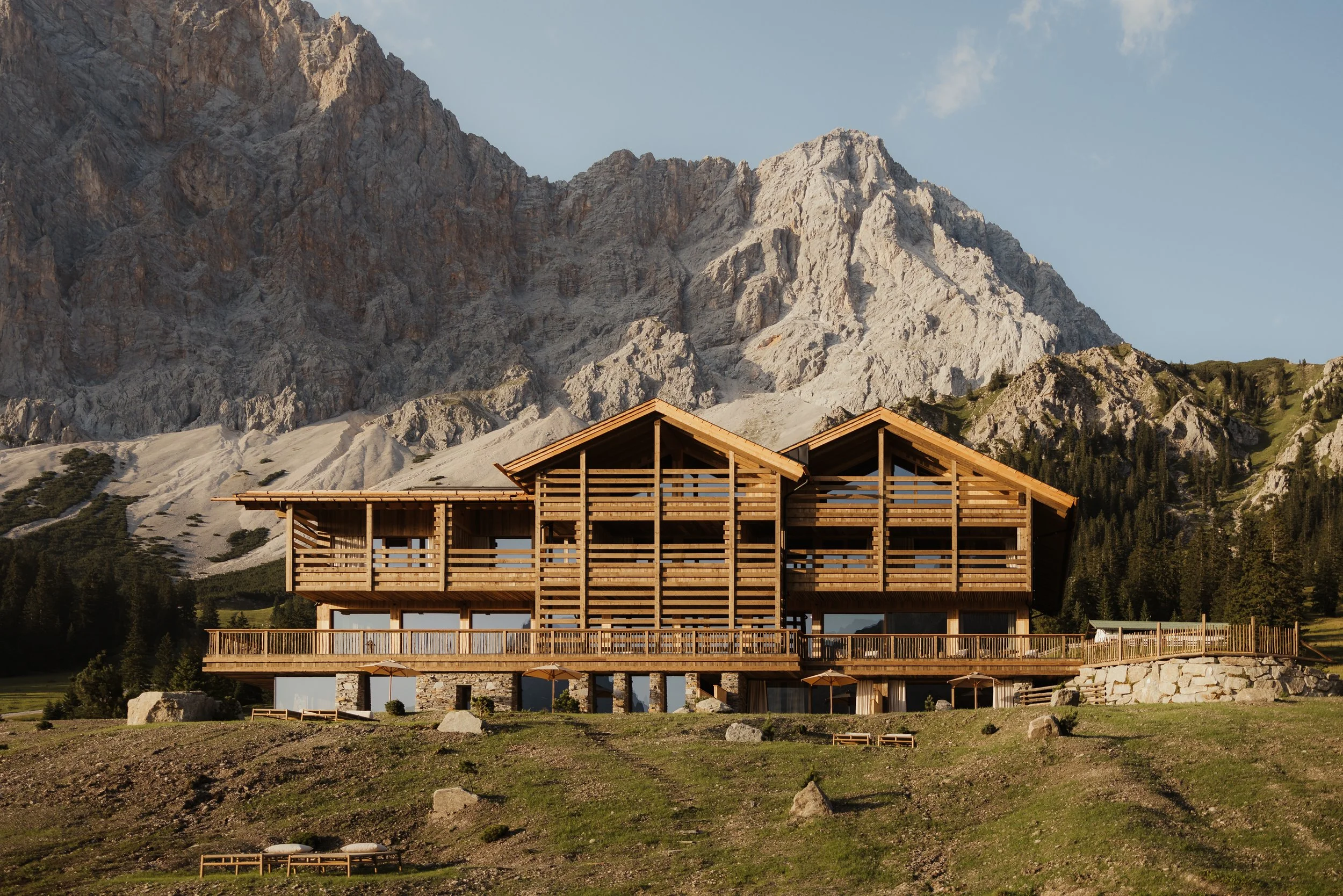 Modern wooden chalet at Eriro Retreat in the Austrian Alps, set against dramatic mountain peaks