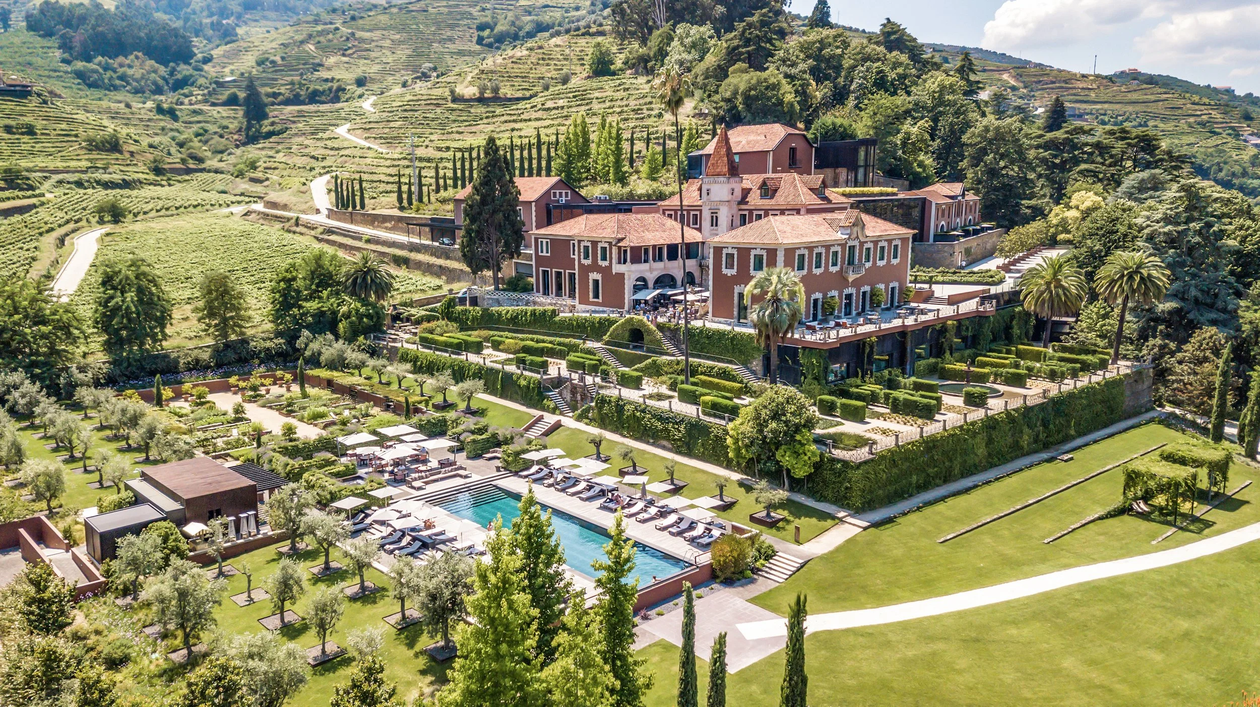 Aerial view of Six Senses Douro Valley in Portugal, surrounded by terraced vineyards along the river