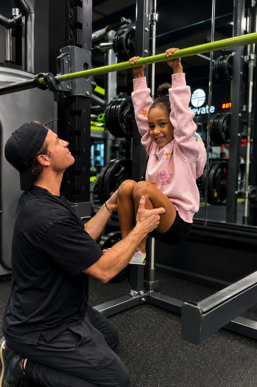 Trainer assists child on the pull-up bar.