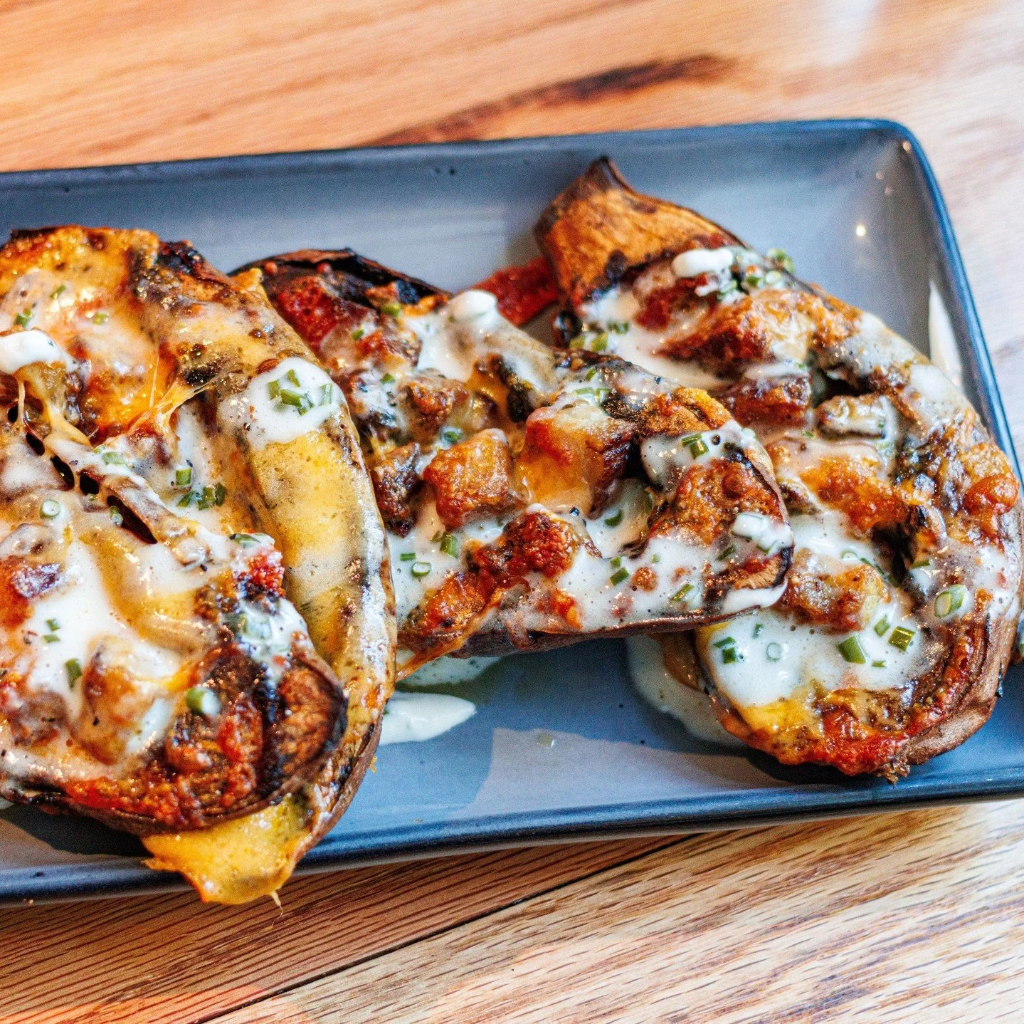 A decadent take on a classic bite&mdash;sweet potato skins with sharp cheddar, pork belly, pepper jelly, and chive cr&egrave;me fra&icirc;che.⁠