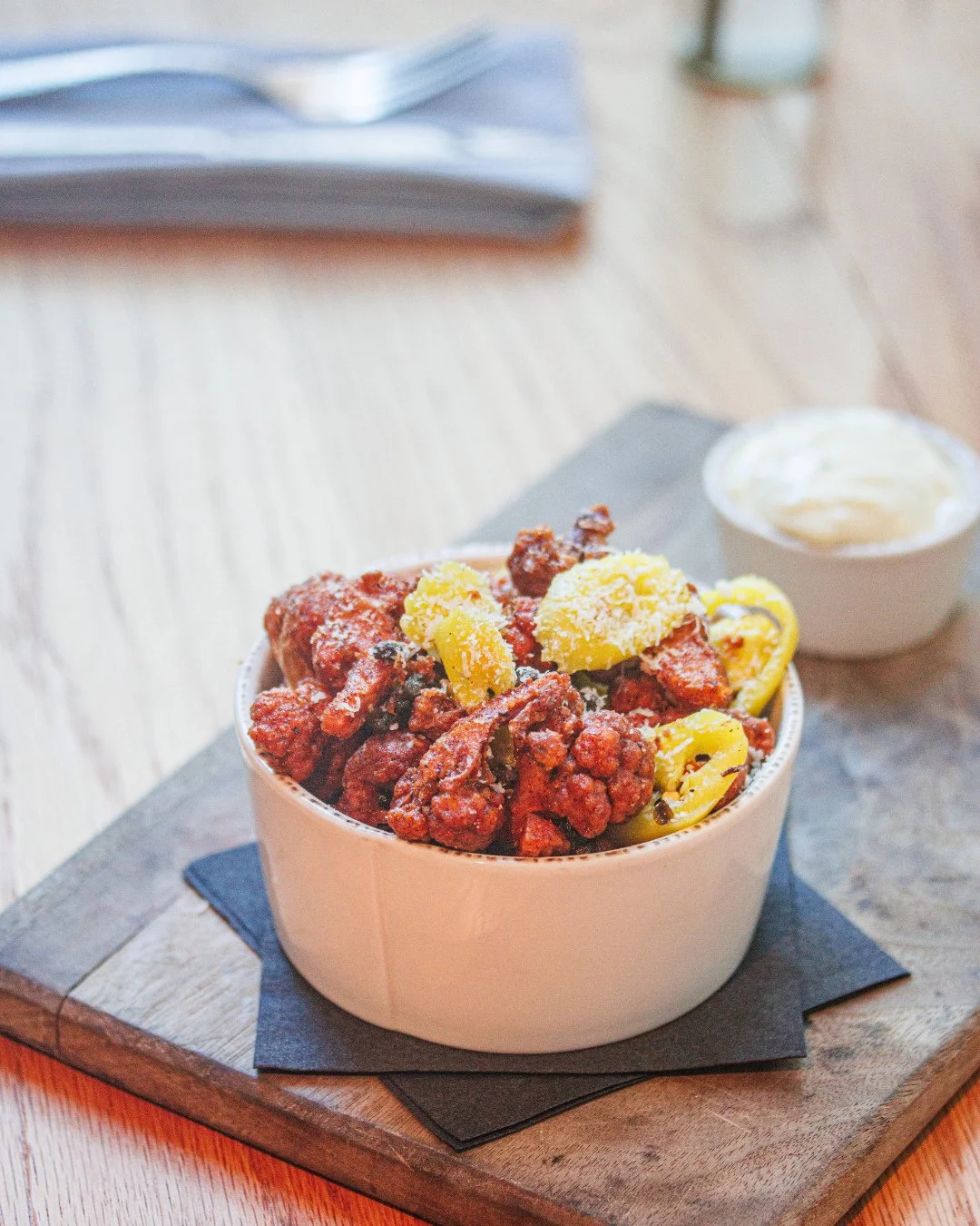 Small plate. Big flavor. Popcorn Cauliflower with truffle aioli, pickled peppers, fried capers, and pecorino.