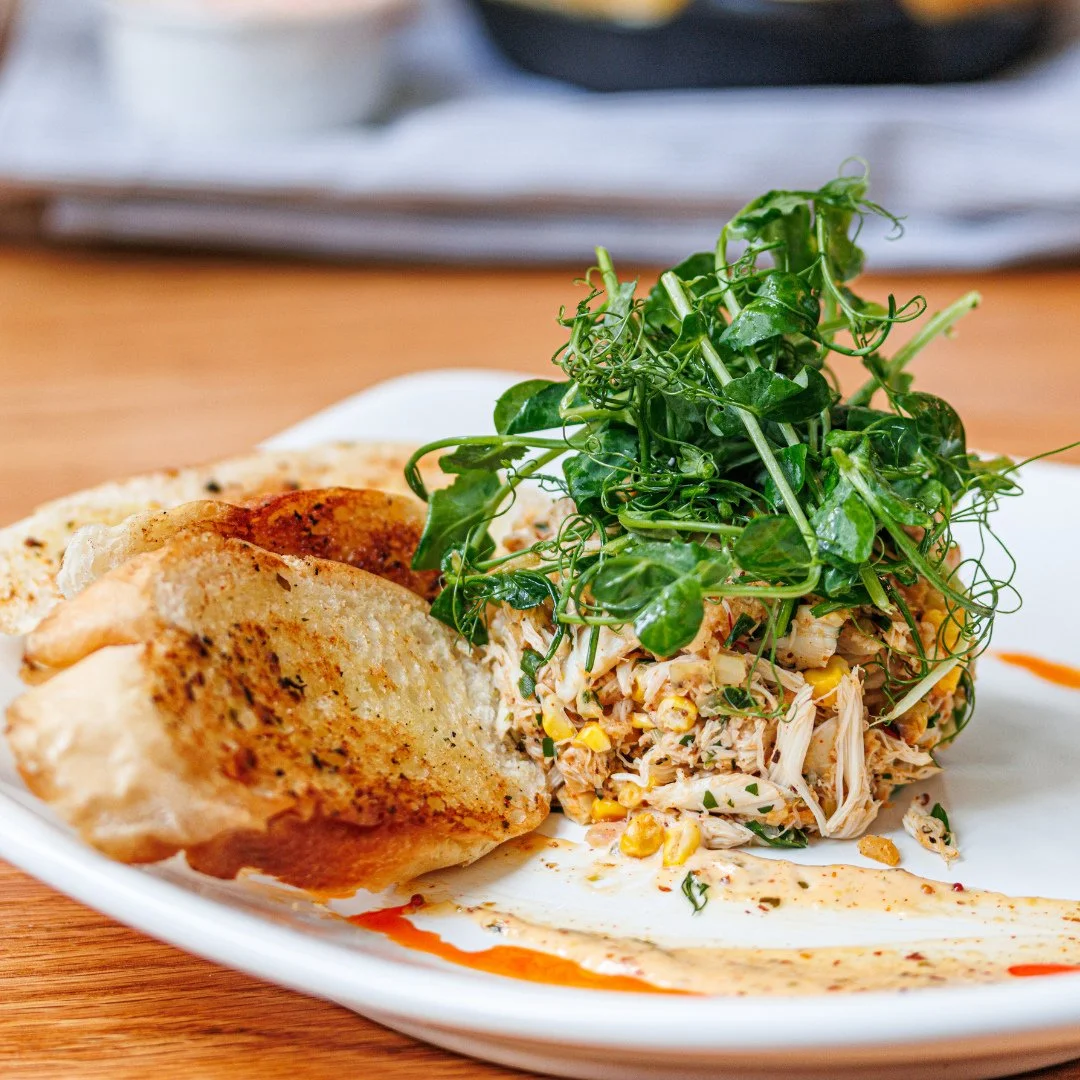 Our Chilled Crab Cake is comprised of blue jumbo crab, charred corn, spring peas, tarragon remoulade, smoked apple bacon dust and preserved lemon. A must-try dish on our new spring menu.✨