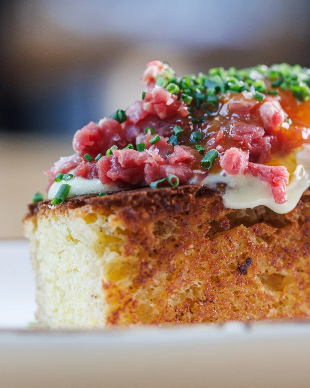 Familiar Southern flavors, in an unexpected form.

Our Carne Cruda layers beef tartare with cornbread, parmesan aioli and Worcestershire-cured egg yolk for a first course with plenty to discover.
