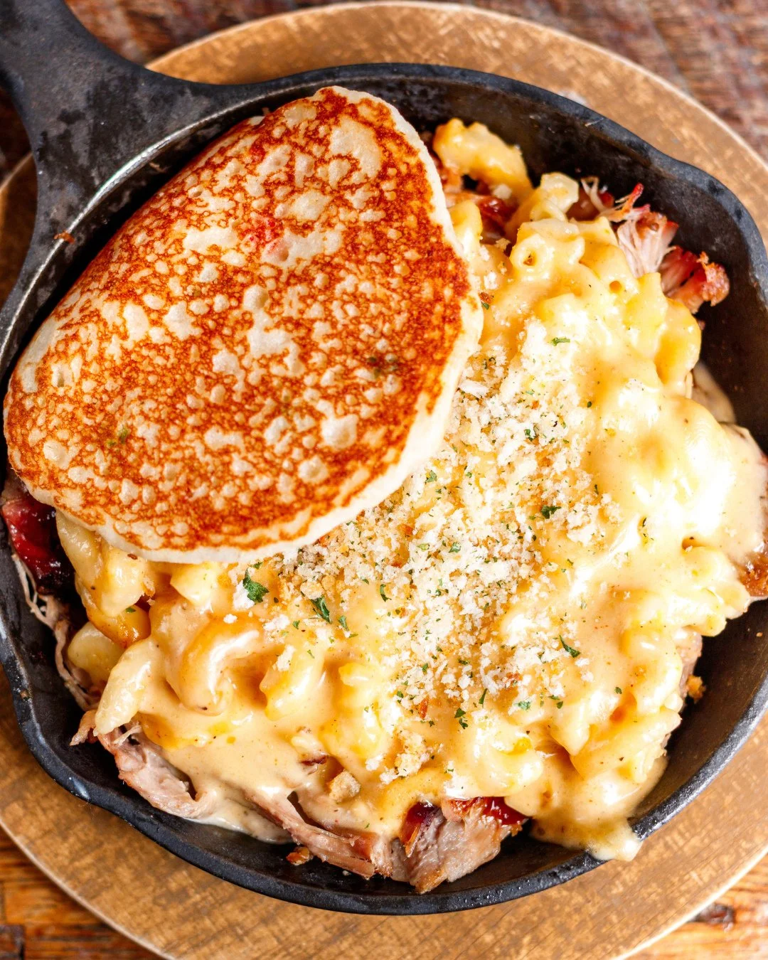 This is what comfort looks like.🍴The Piggy Mac brings together cherry wood-smoked pulled pork, creamy white cheddar mac n' cheese and crispy biscuit crumbs in one cast iron skillet.