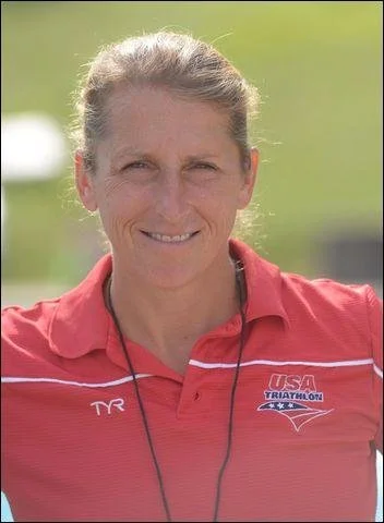 Coach Joella Baker smiling outdoors in a USA Triathlon polo