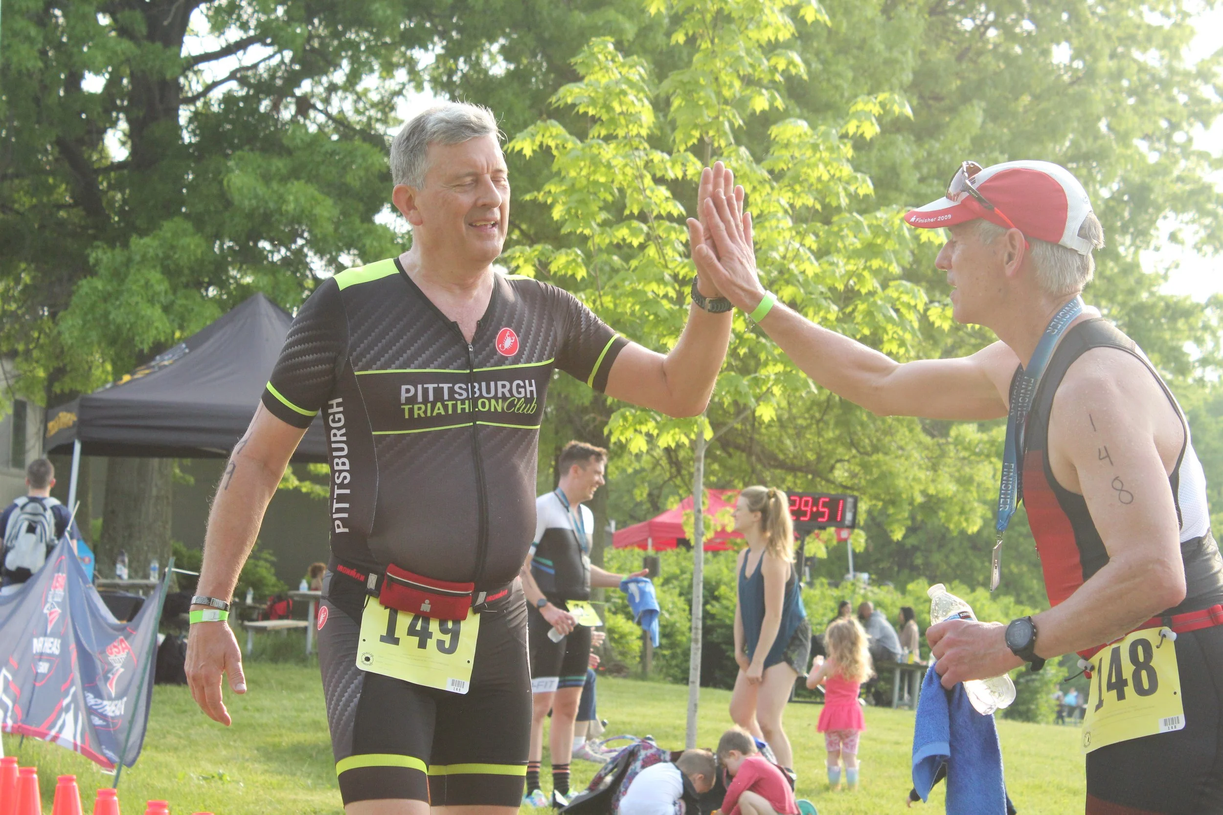 Two athletes celebrating with a high five after a race