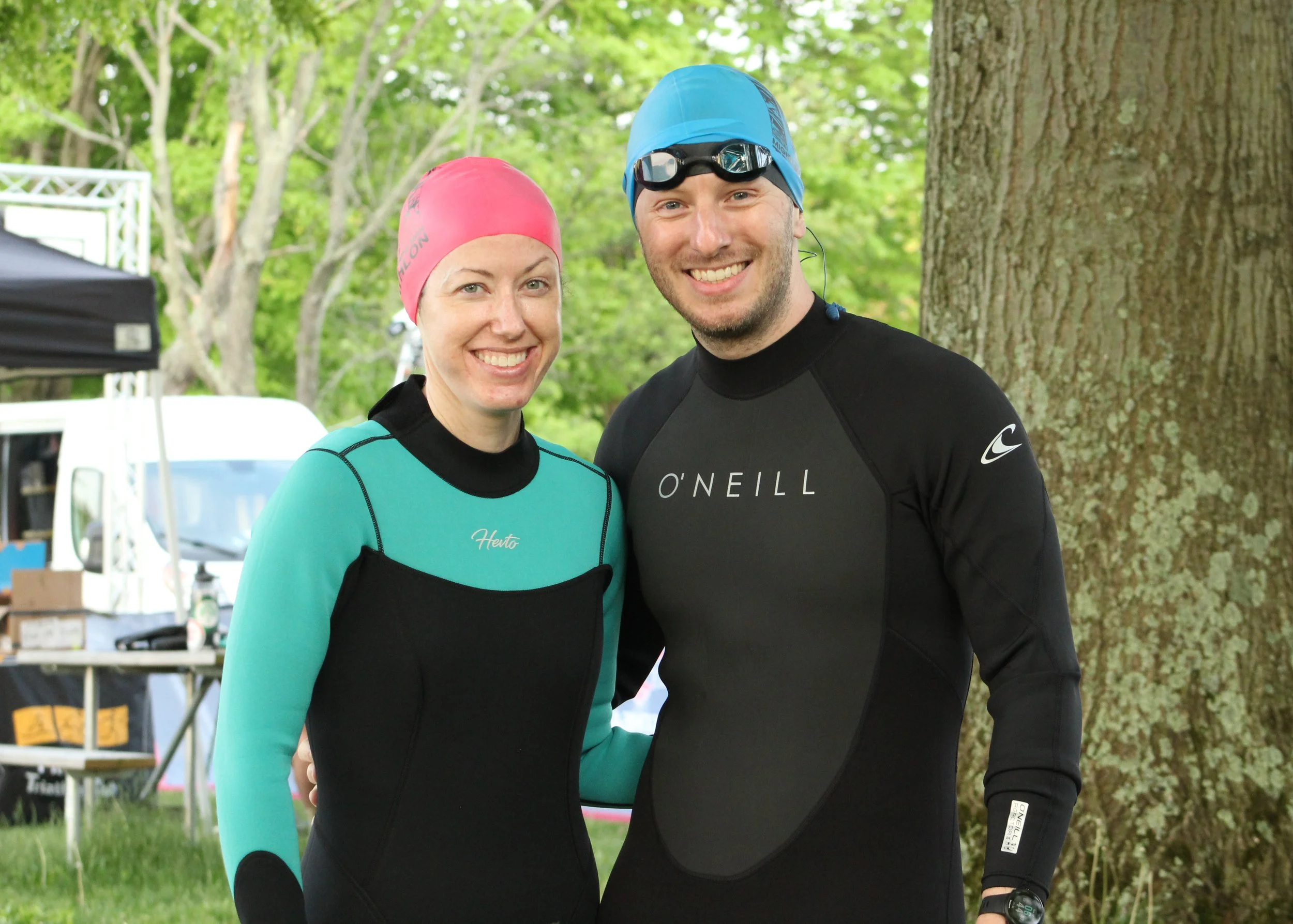 Two athletes in swim caps and wetsuits before Mighty Moraine