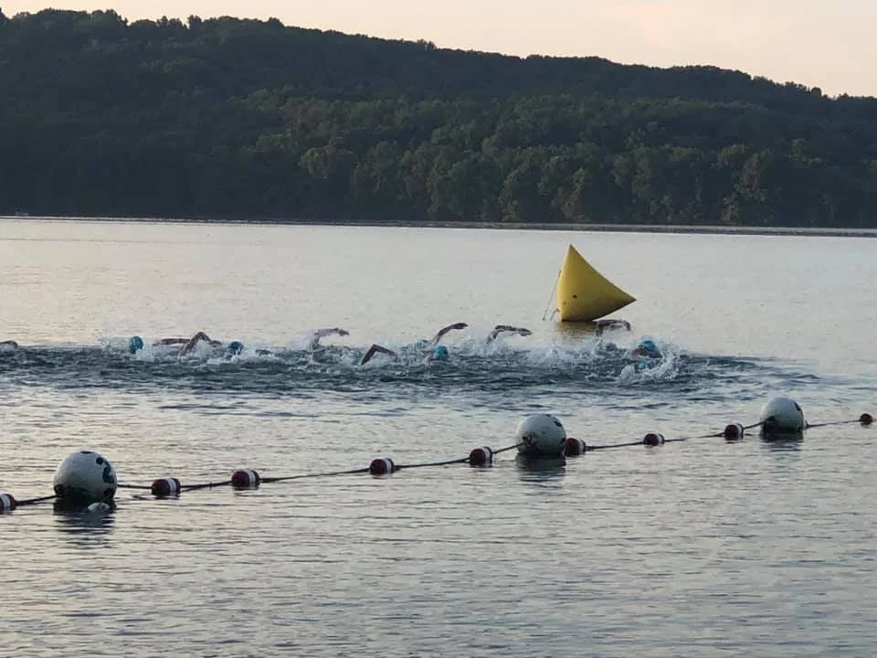 Swimmers rounding a yellow buoy on Lake Arthur