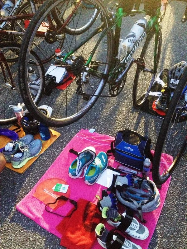Shoes, a helmet, and bikes laid out in transition