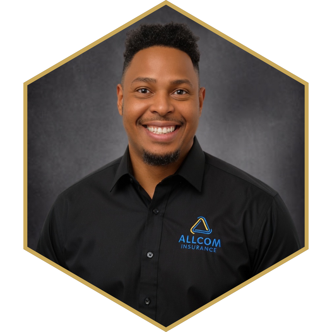 Portrait of a smiling man wearing a black shirt with 'ALLCOM INSURANCE' logo on it, against a dark background.