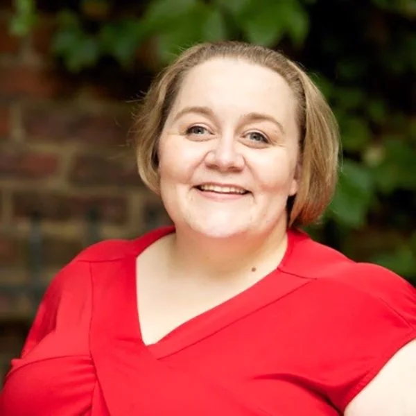 Smiling woman with short blonde hair and red v-neck shirt