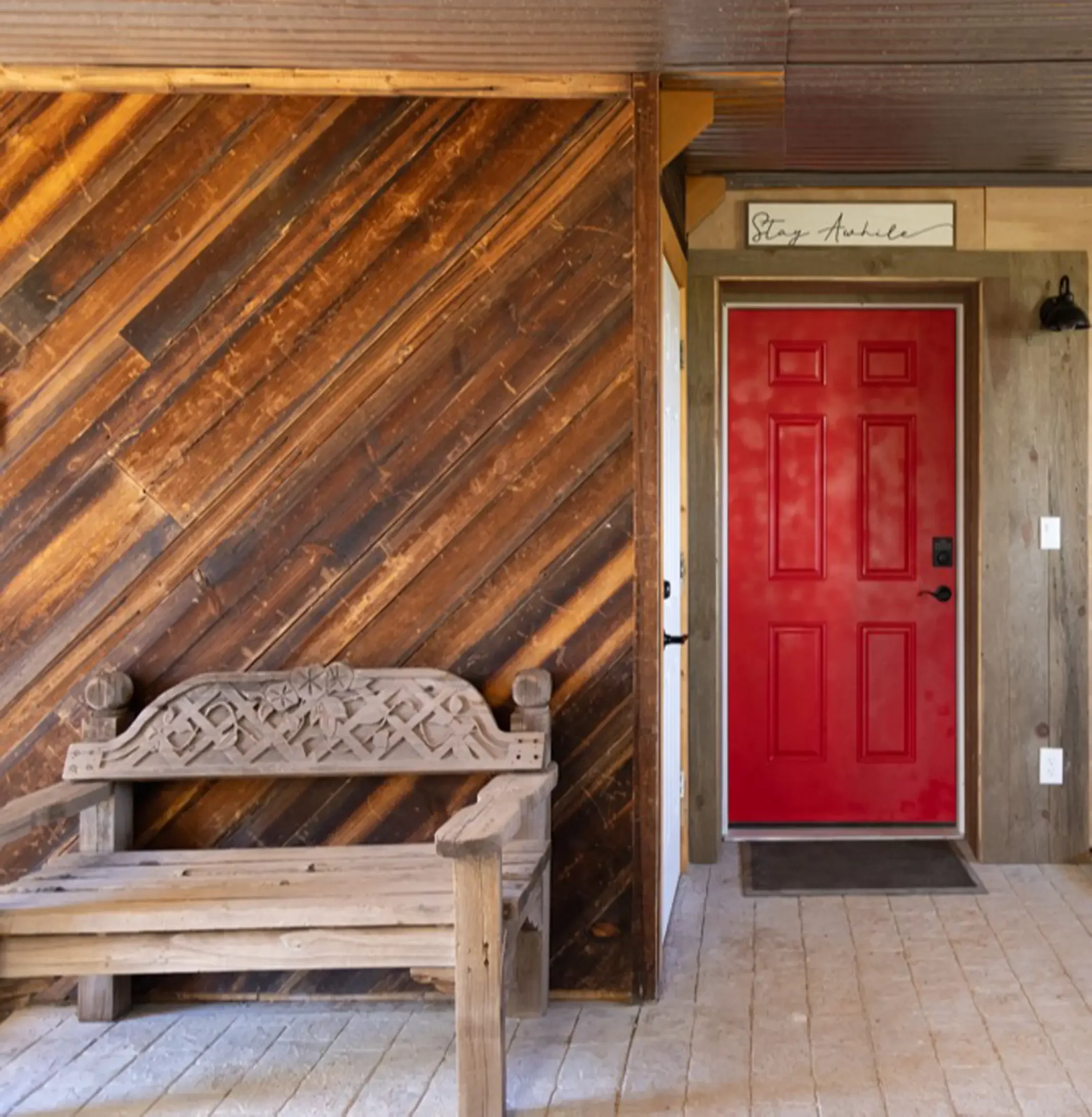 Interior of an establishment with reclaimed wood decor, a red door, and a sign that reads 'Stag Avenue' above the door.