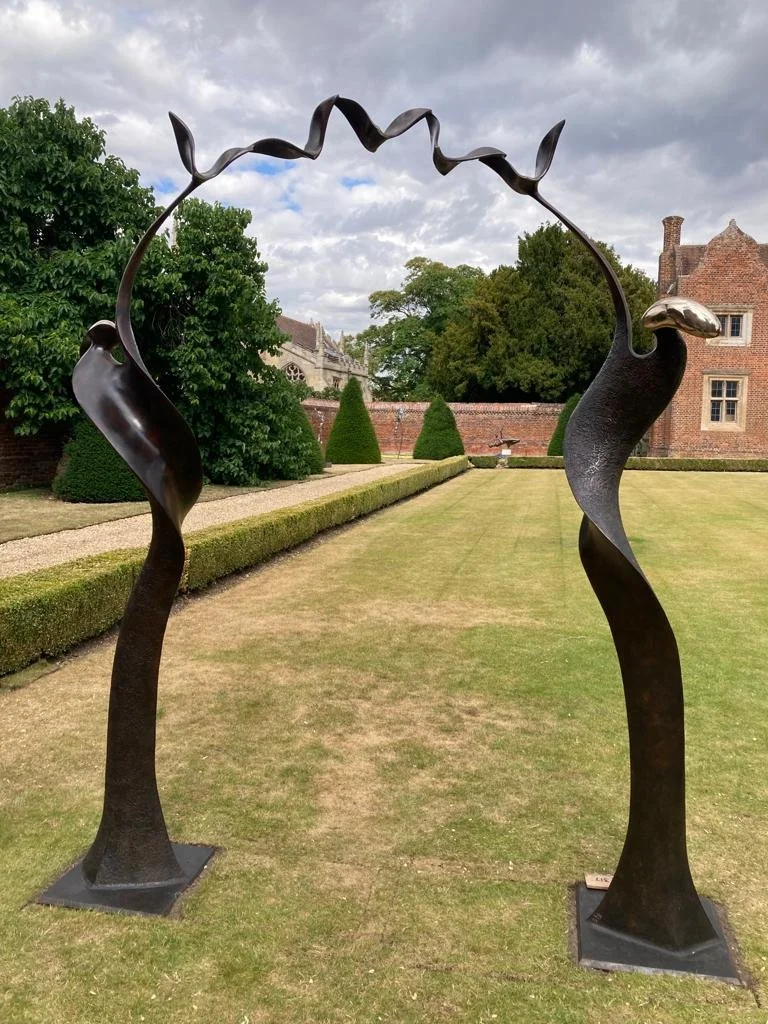 Arch Sandra Bell garden sculpture cast bronze figure spiral aloft birds curved ribbon unfurl golden head arch support deep browns tree bough peaceful mythological metal modern art sustainable ireland