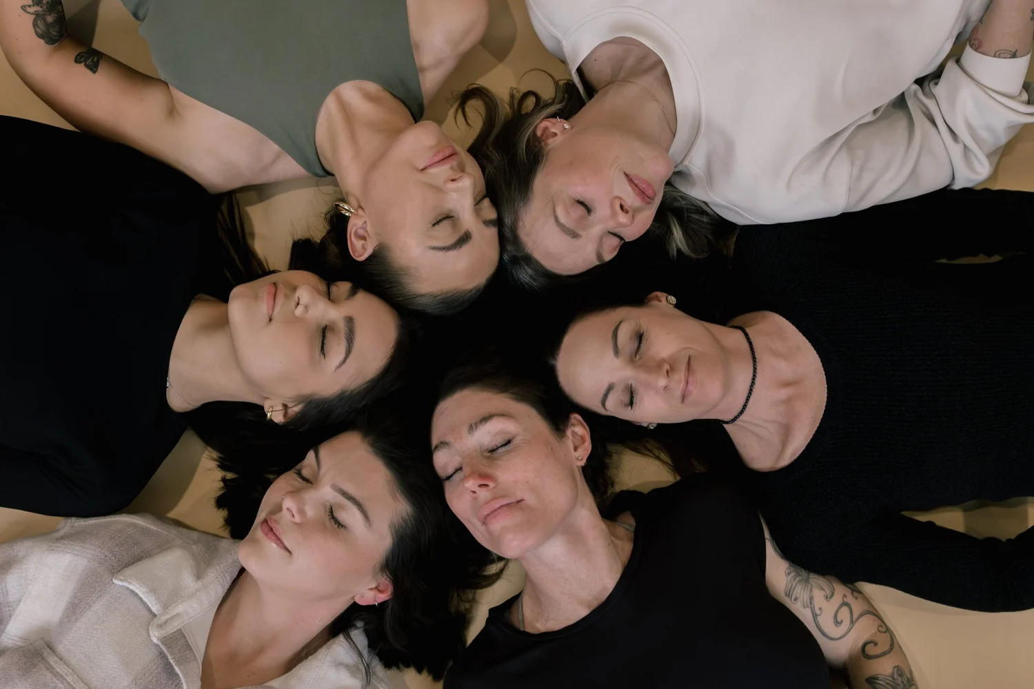 Girls lying in a circle with their heads together