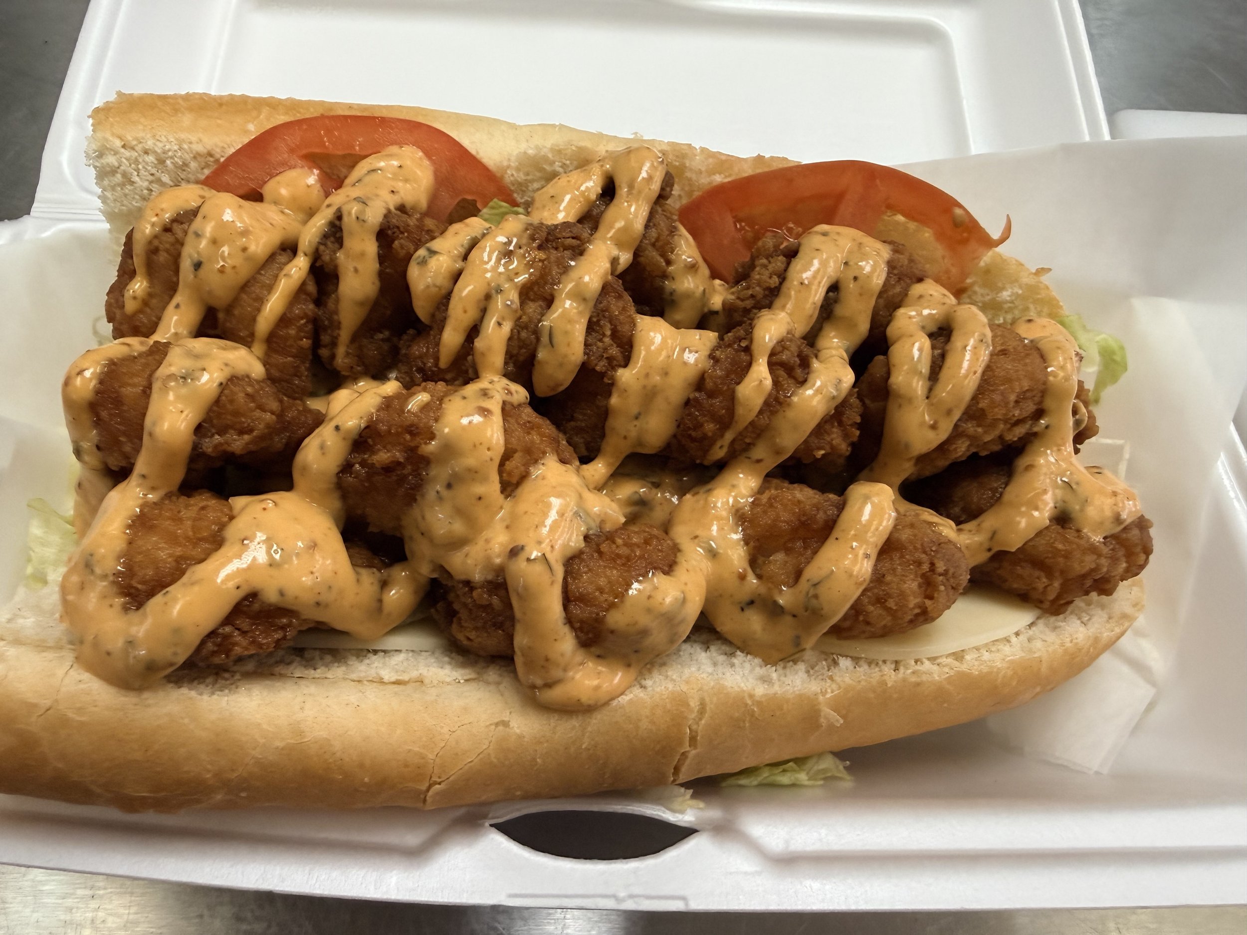 The Po' Boy with honey battered shrimp, cheese, lettuce, tomato, and our house made Remoulade sauce.
