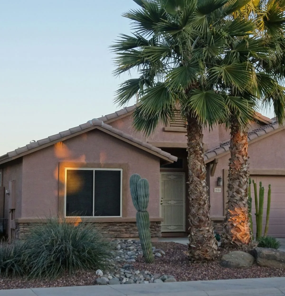 Arizona home with desert landscaping, palm trees, and cactus