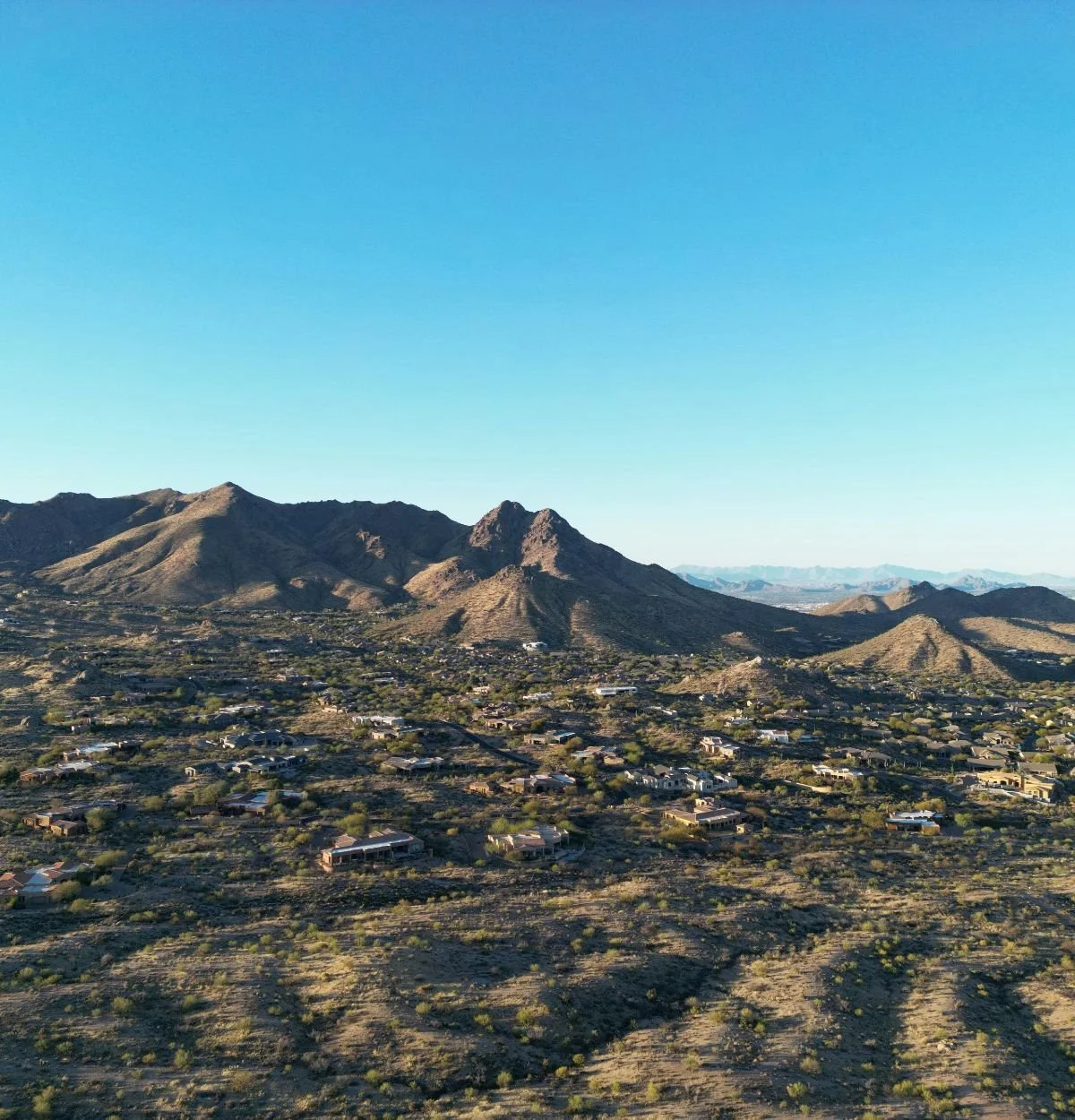 Aerial view of homes and roads surrounded by desert terrain in Scottsdale, Arizona