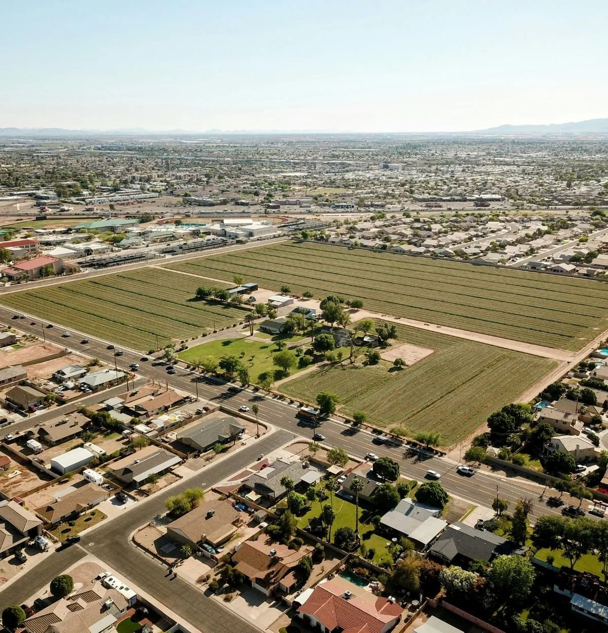 Aerial view of a residential development site with roads, lots, and active construction
