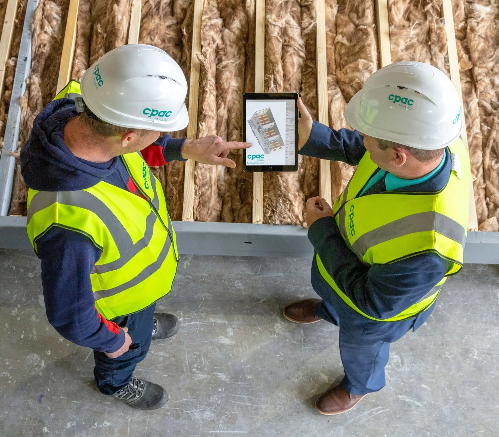 Construction professionals reviewing updated project plans at a job site.