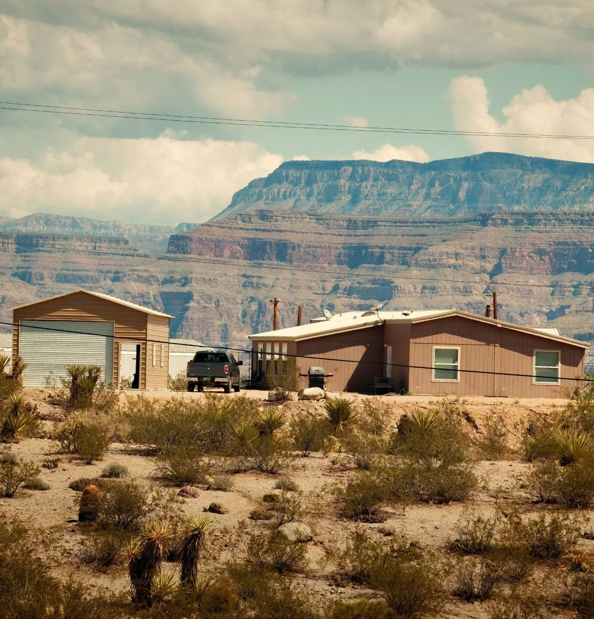 Desert home on an Arizona property with red rock cliffs and native vegetation in the background
