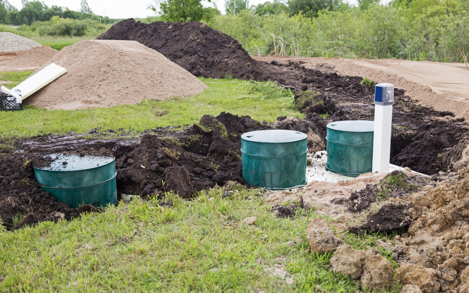 Alternate septic system installation with three access risers and an above-ground control panel.