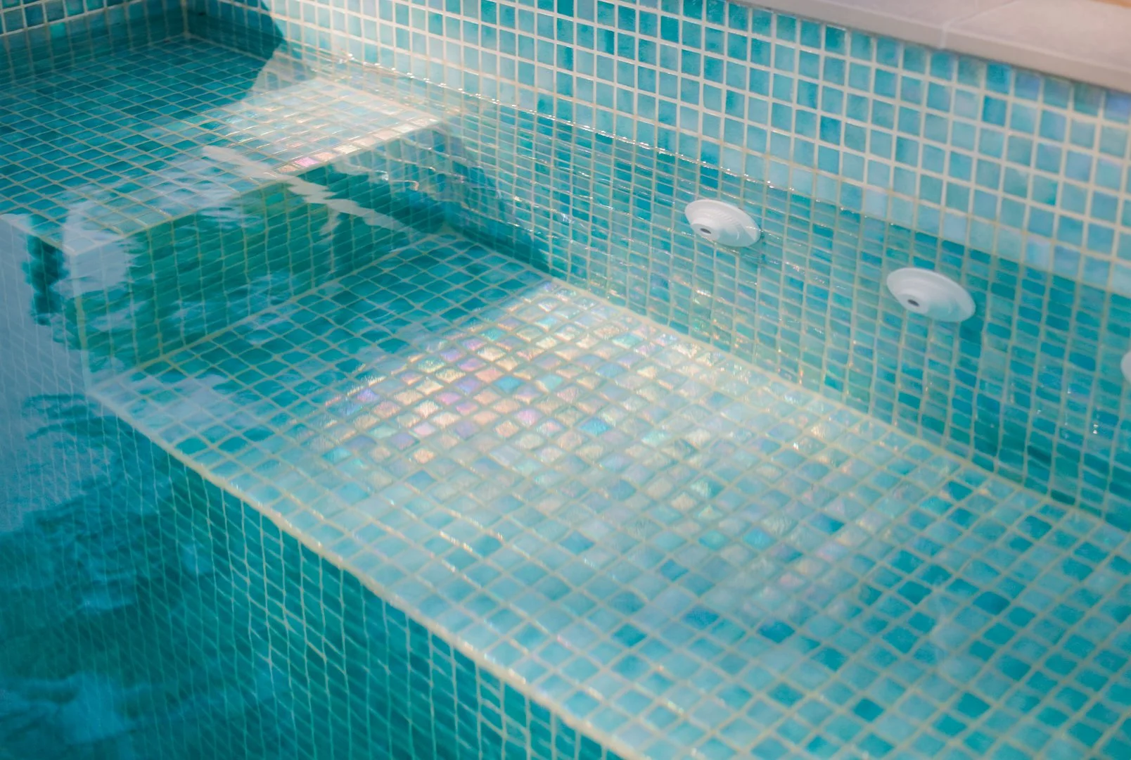 FULLY CUSTOM MOSAIC TILED PLUNGE POOL INTERIOR WITH JETS ON THE BENCH. 