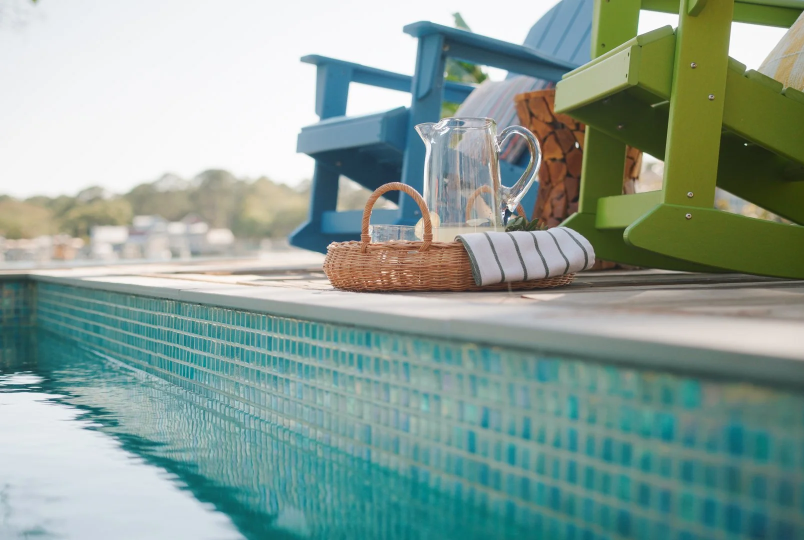 ENTERTAINING POOLSIDE WITH A FULLY CUSTOM MOSAIC-TILED COCKTAIL POOL AS THE FOCAL POINT, OVERLOOKING THE MARSH IN HILTON HEAD, SOUTH CAROLINA.