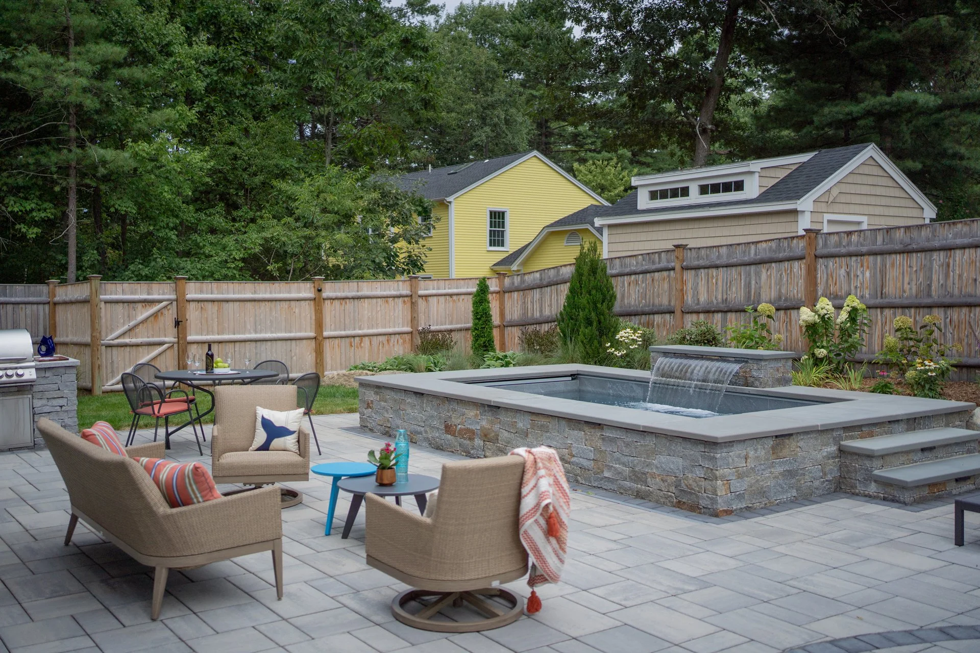 [raised][large-spaces]SOAKE POOL WITH WATERFALL FEATURE ANCHORS THIS NEWBURYPORT OUTDOOR LIVING SPACE