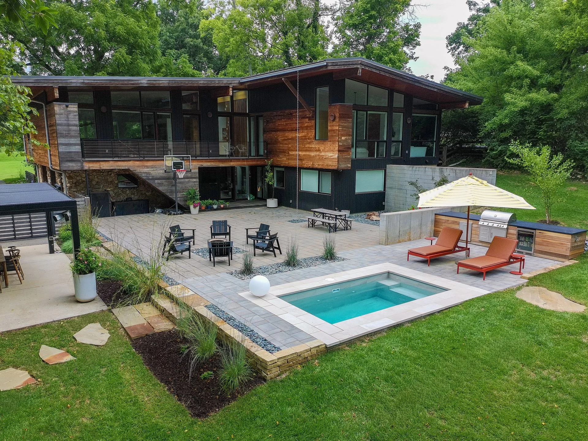 [flush][large-spaces]COURTYARD BACKYARD WITH PLUNGE POOL, OUTDOOR KITCHEN, BASKETBALL HOOP, AND PERGOLA.