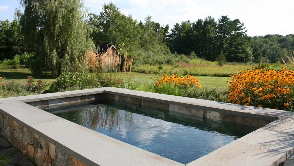 First Soake Pool installation in the United States featuring a precast concrete plunge pool with rectangular design, stone coping, and natural landscaping, representing early plunge pool design and modern outdoor living inspiration.