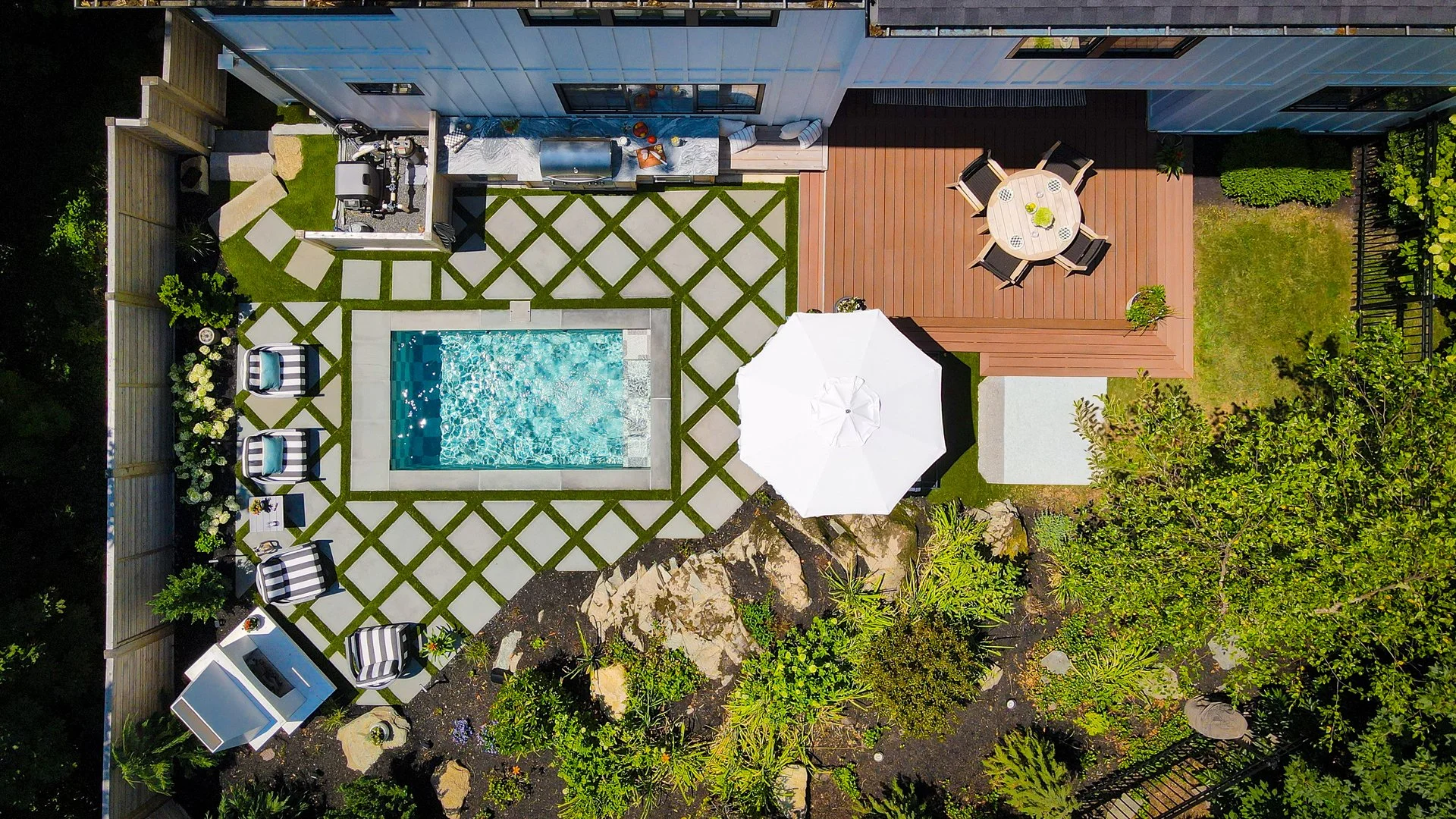 [small-spaces]AERIAL VIEW OF A COMPACT SOAKE POOL WITH AN OUTDOOR KITCHEN AND FIREPLACE.
