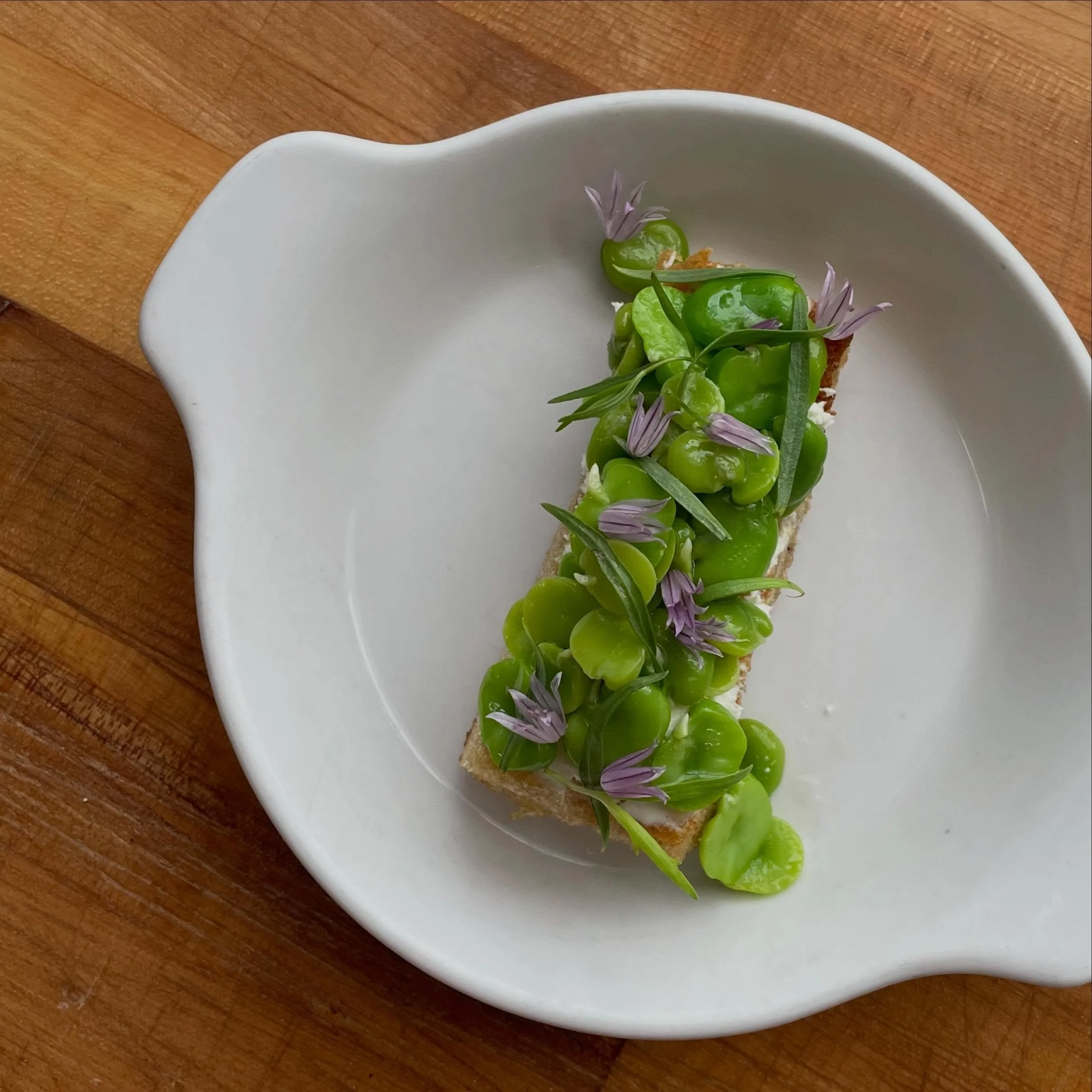 Fresh fava beans, whipped sheep cheese, tarragon, chive flowers, &amp; good olive oil all on olive oil fried focaccia 💁🏻&zwj;♀️ a little snack we&rsquo;ll be specialing on and off this season 🌱