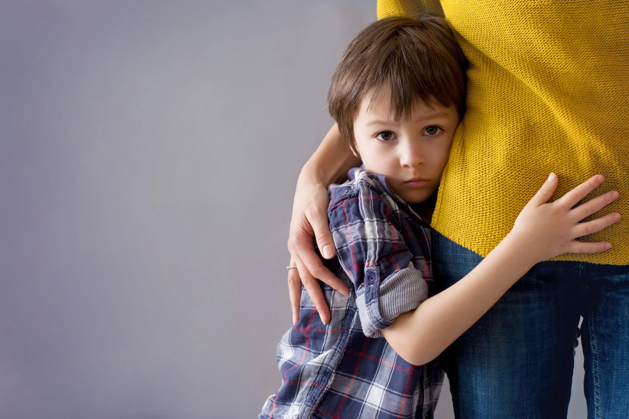 Anxious child holding onto caregiver