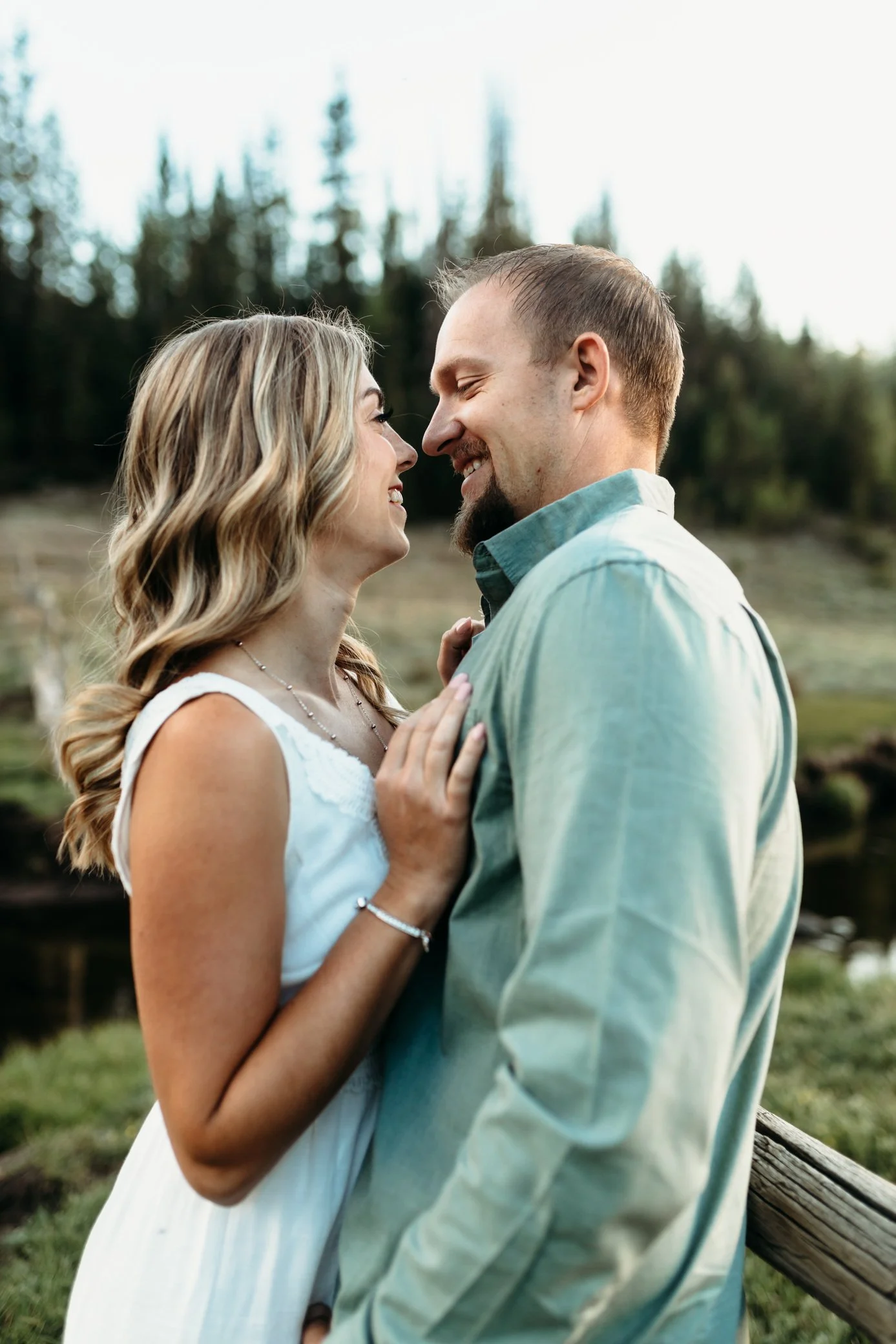 engaged couple embracing on the mountains
