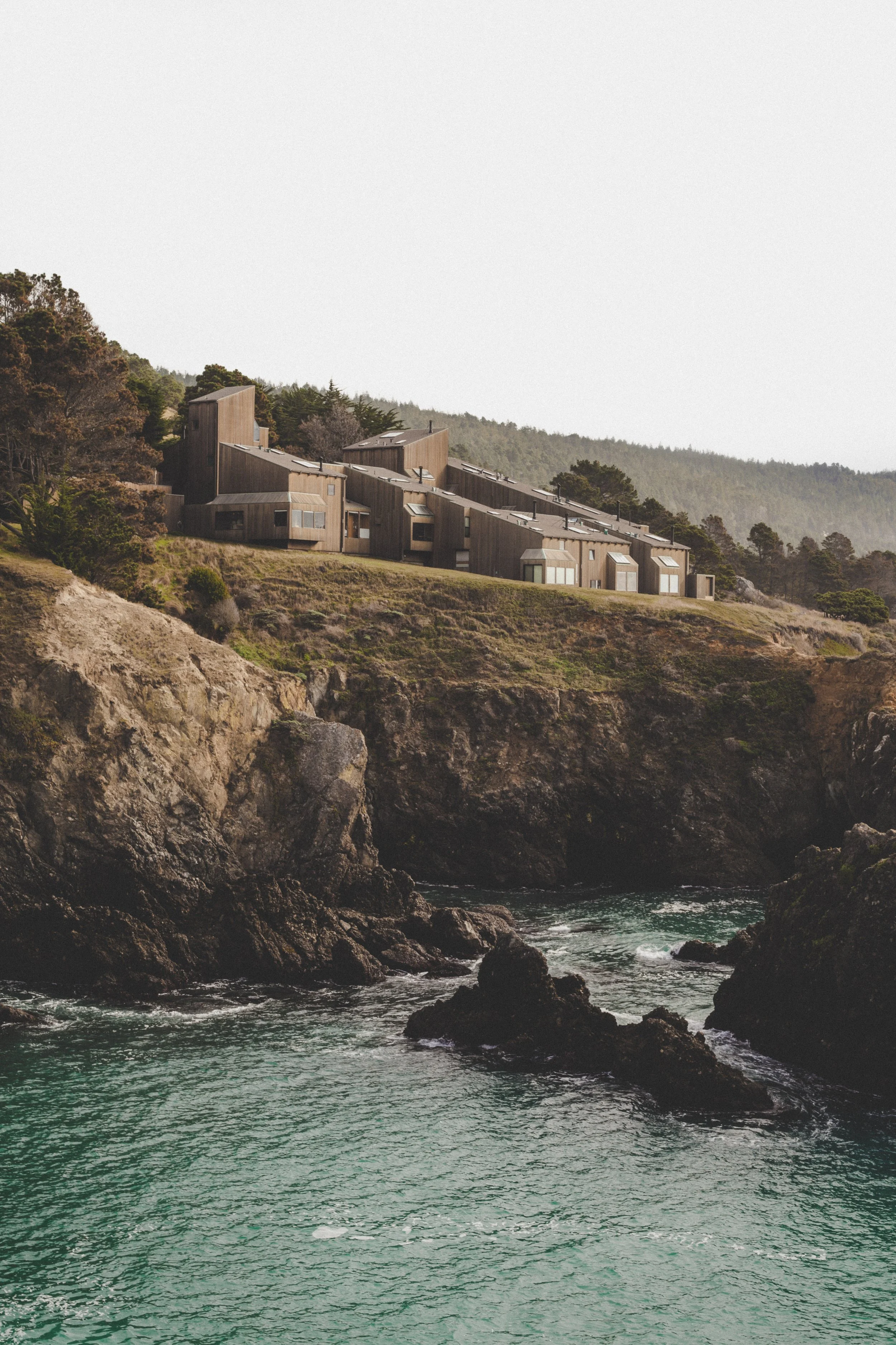 House in Sea Ranch on a hill overlooking rocky coast and ocean.