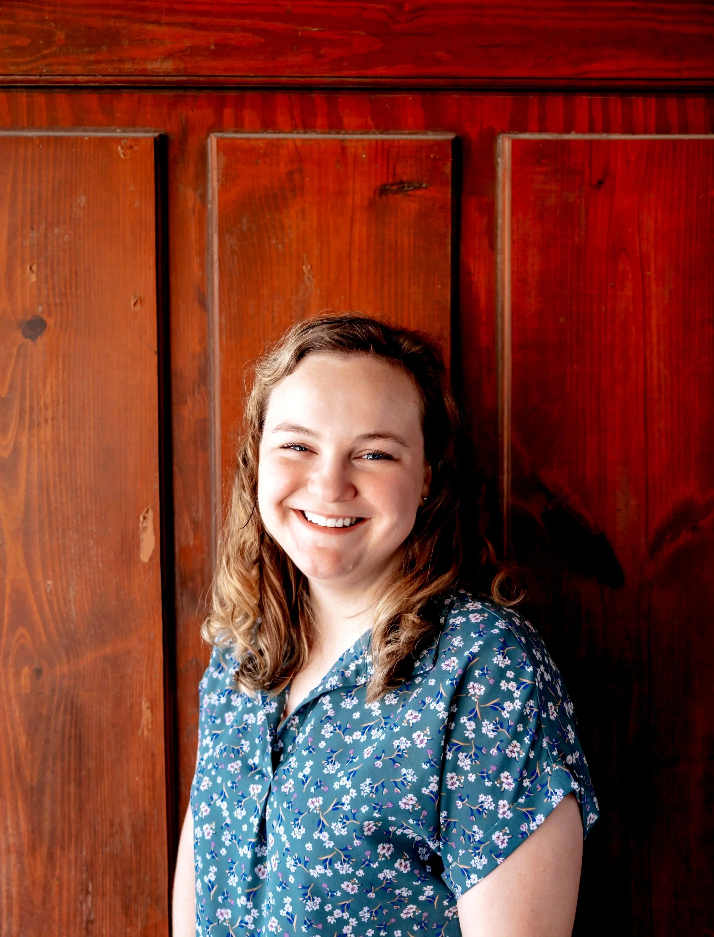 This is another picture of Jessica McClain, LCSW, a therapist at Heart of Texas Therapy Services who specializes in treating anxiety and OCD. She has a warm smile and is standing in front of a door.